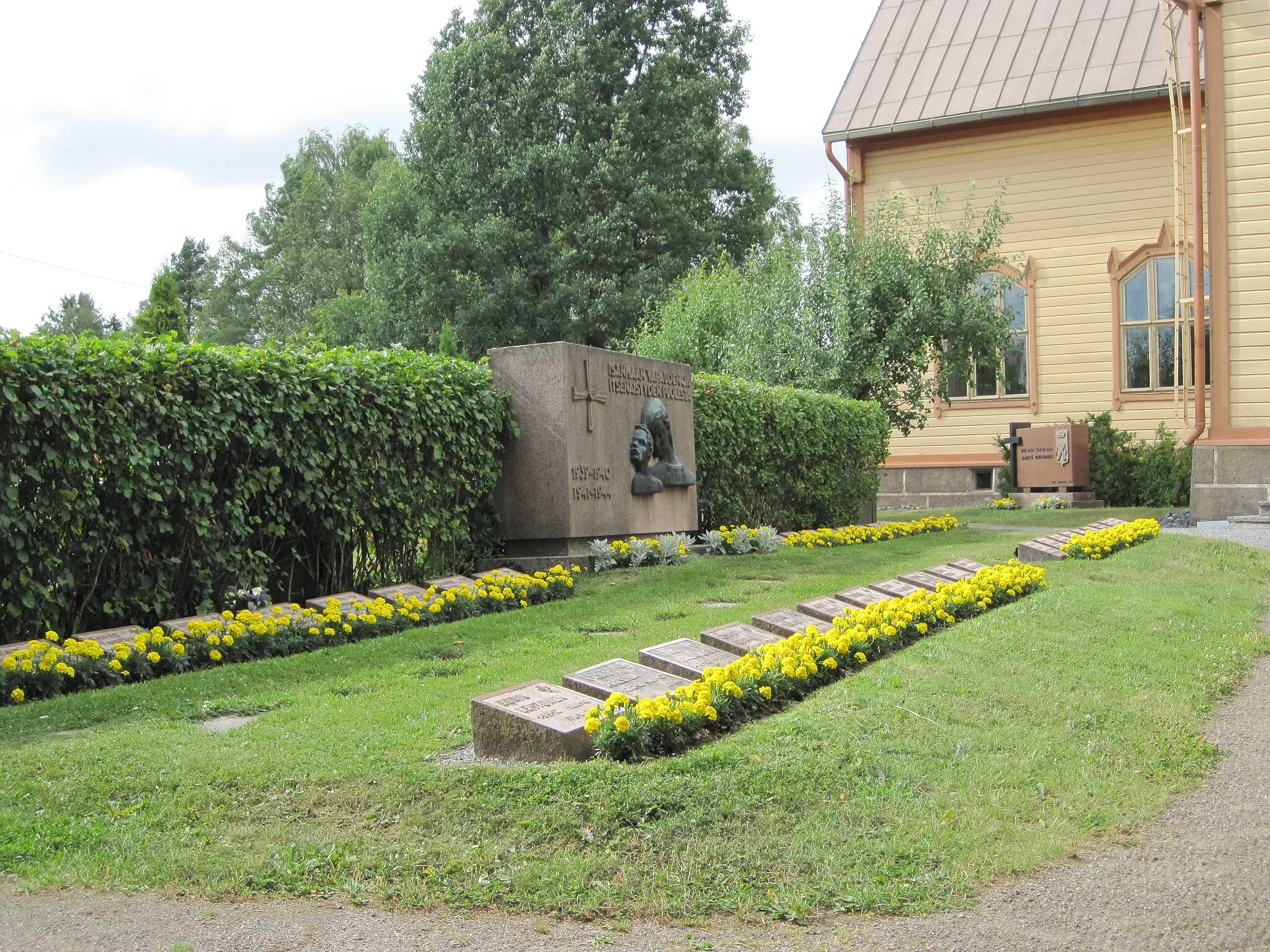 Photo showing: Military cemetary at Aura church in Aura, Finland. Relief by Jussi Vikainen (1907-1992), unveiled in 1956.