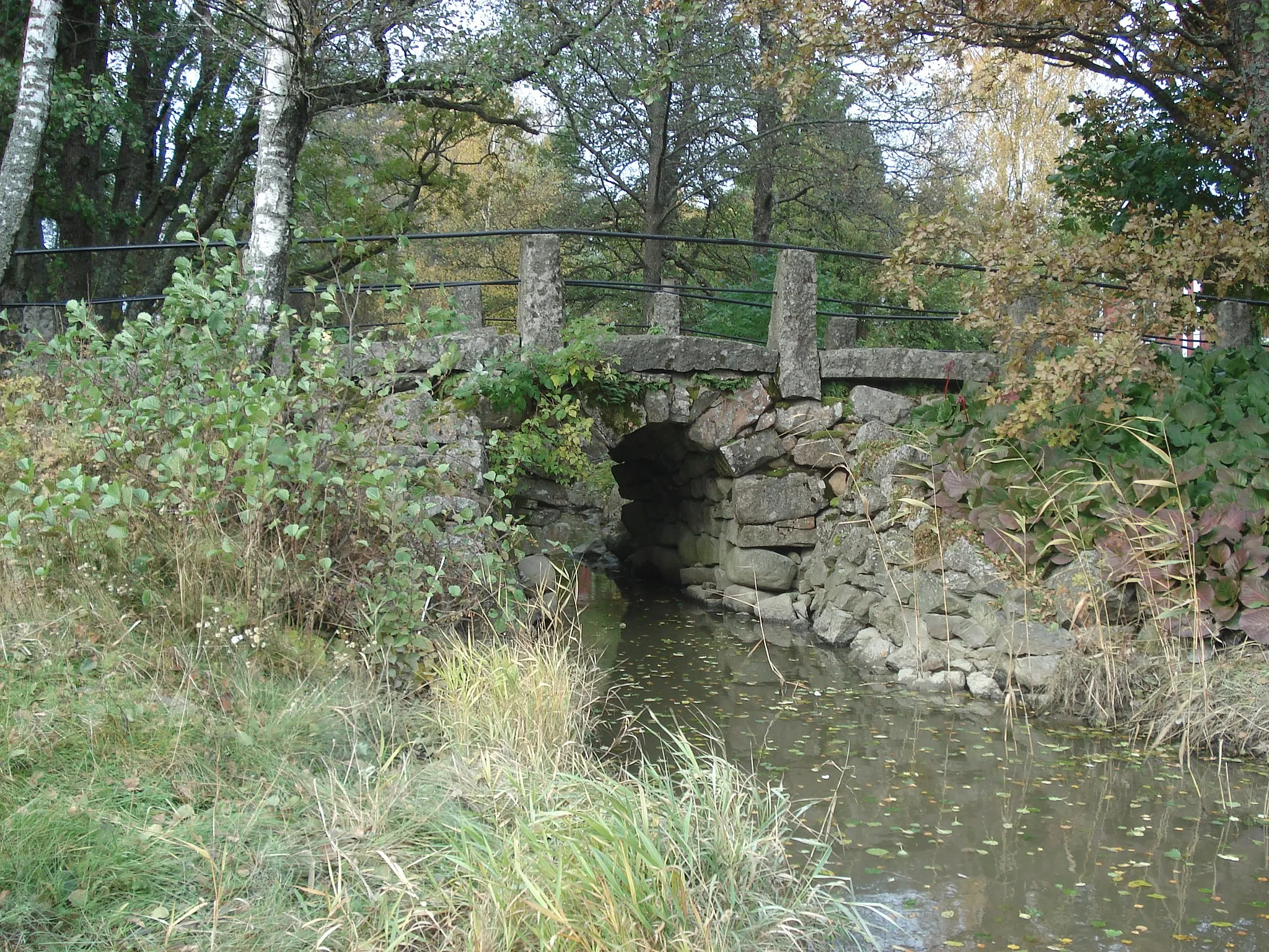 Photo showing: The Muntti Bridge is located on an absolete section of the Turku–Taivassalo road in Finland. This small single-span stone-vault bridge was built in 1850 to link the village of Koivisto to Taivasalo. The bridge was approved as a museum bridge in 1982.