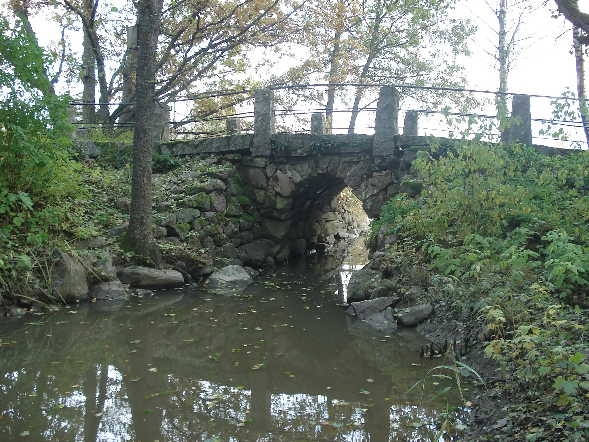 Photo showing: The Muntti Bridge is located on an absolete section of the Turku–Taivassalo road in Finland. This small single-span stone-vault bridge was built in 1850 to link the village of Koivisto to Taivasalo. The bridge was approved as a museum bridge in 1982.