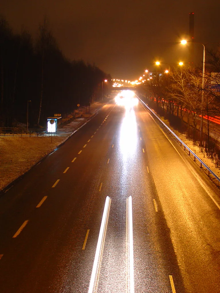 Photo showing: A view from a bridge crossing the Ring road I (regional road 101) in Lassila, Helsinki, Finland. The picture has been taken from Klaneettipolku bridge, looking east. It was 5 pm yet it was rather dark already. It was also raining and I had to cover my camera with a newspaper.