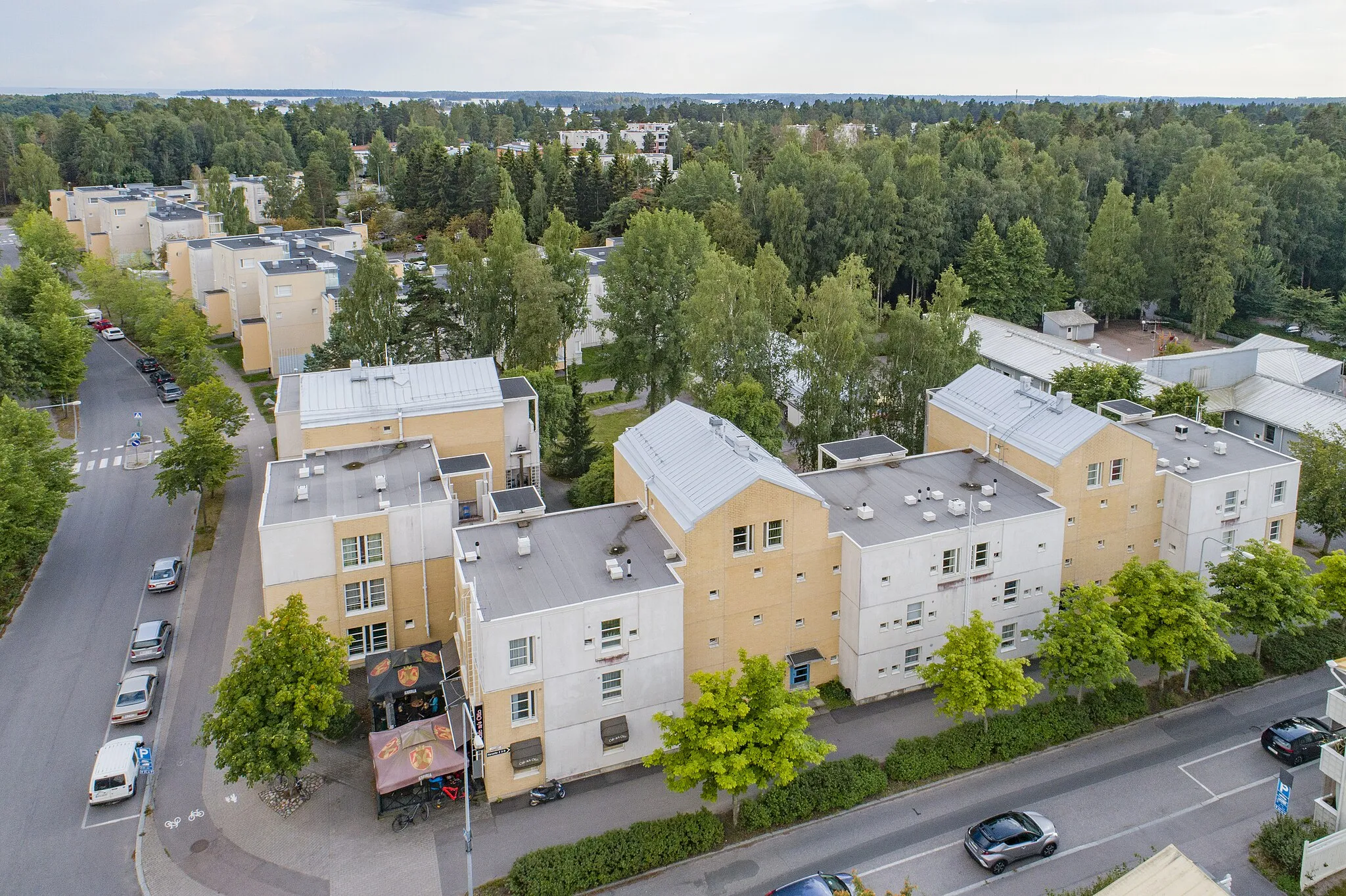 Photo showing: Osoitteessa Harustie 2, Halkaisijantie 3 sijaitsevat, Kiinteistö Oy Merirastilaan kuuluvat asuinkerrostalot ovat osa Helsingin kaupungin asunnot Oy:n (Heka) vuokra-asuntokohdetta nimeltä Halkaisijantie 2. Rakennukset on suunnitellut Arkkitehtitoimisto Helin & Siitonen, ja ne ovat muiden kiinteistöyhtiöön kuuluvien rakennusten (Halkaisijantie 2, Päiväkoti Rastila osoitteessa Halkaisijanpolku 1) tavoin valmistuneet vuonna 1991.
Harustien ja Halkaisijantien risteyksessä sijaitsevien kolme- ja neljäkerroksisten asuintalojen julkisivua rytmittävät muun muassa tasakattojen ja harjakattojen vuorottelu sekä poikkipäädyt. Harustien puoleisen rakennuksen katutasossa on kahvila, jonka terassi avautuu Halkaisijankadun puolelle.
Oikeassa reunassa, asuinrakennusten länsipuolella, näkyy osoitteessa Harustie 4 sijaitsevan Päiväkoti Katiskan kattorakenteita ja piha-aluetta sekä niitä reunustavaa Haruspuistoa. Vasemmassa yläreunassa pilkottaa Ison Kallahden puisto ja sen takana meri.
Meri-Rastilan läntisen osan asemakaava on vahvistettu 2022.
Itäosan asemakaavan muutos on valitusprosessissa kesällä 2023.

Asemakaavamuutokset mahdollistavat alueen uudistamisen ja useiden rakennusten purkamisen osana Meri-Rastilan kaupunkiuudistusta.