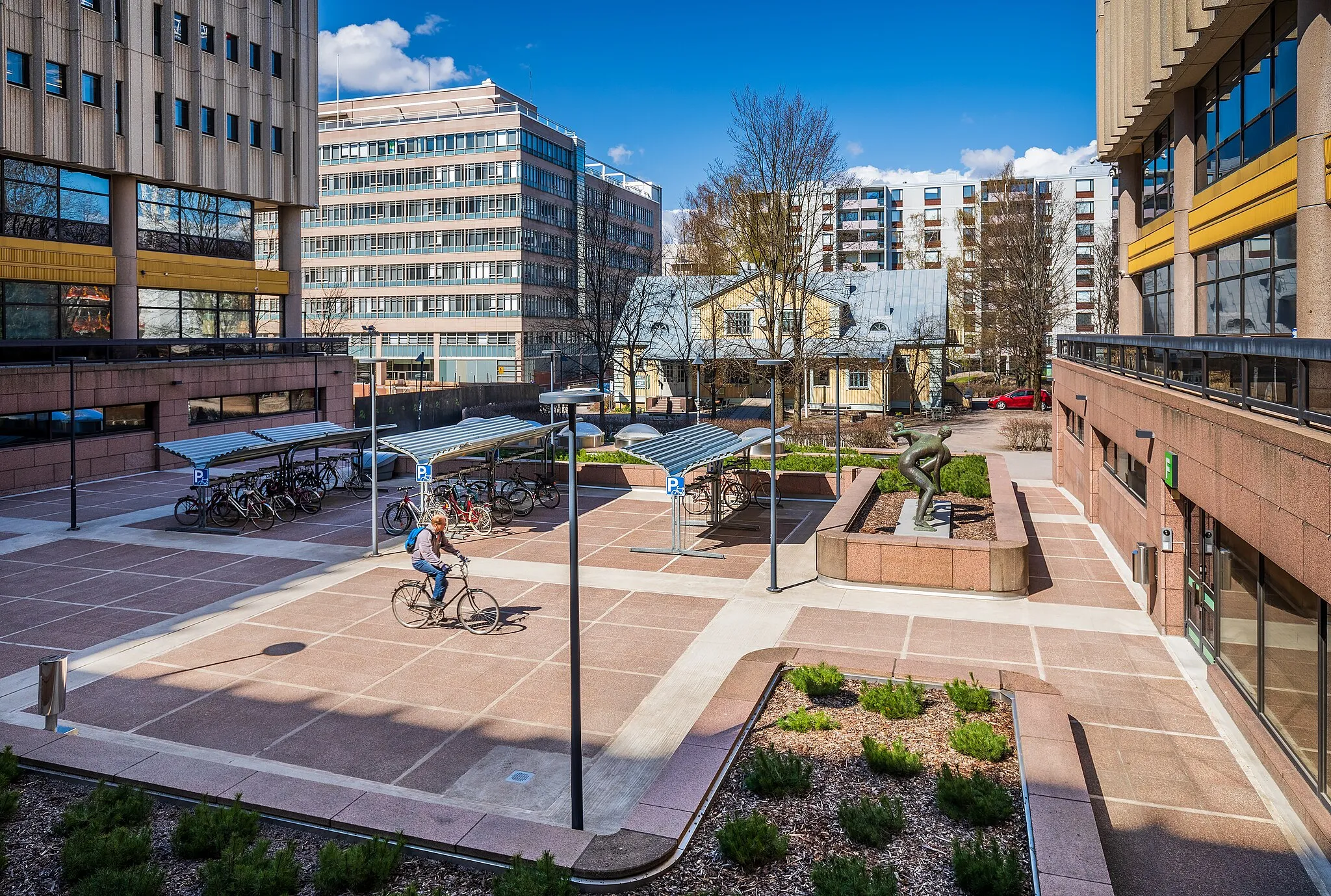 Photo showing: A square or yard by Pasila Office Centre in Itä-Pasila, Helsinki, Finland in 2022 May. The wooden building in the background is Rauhanasema.