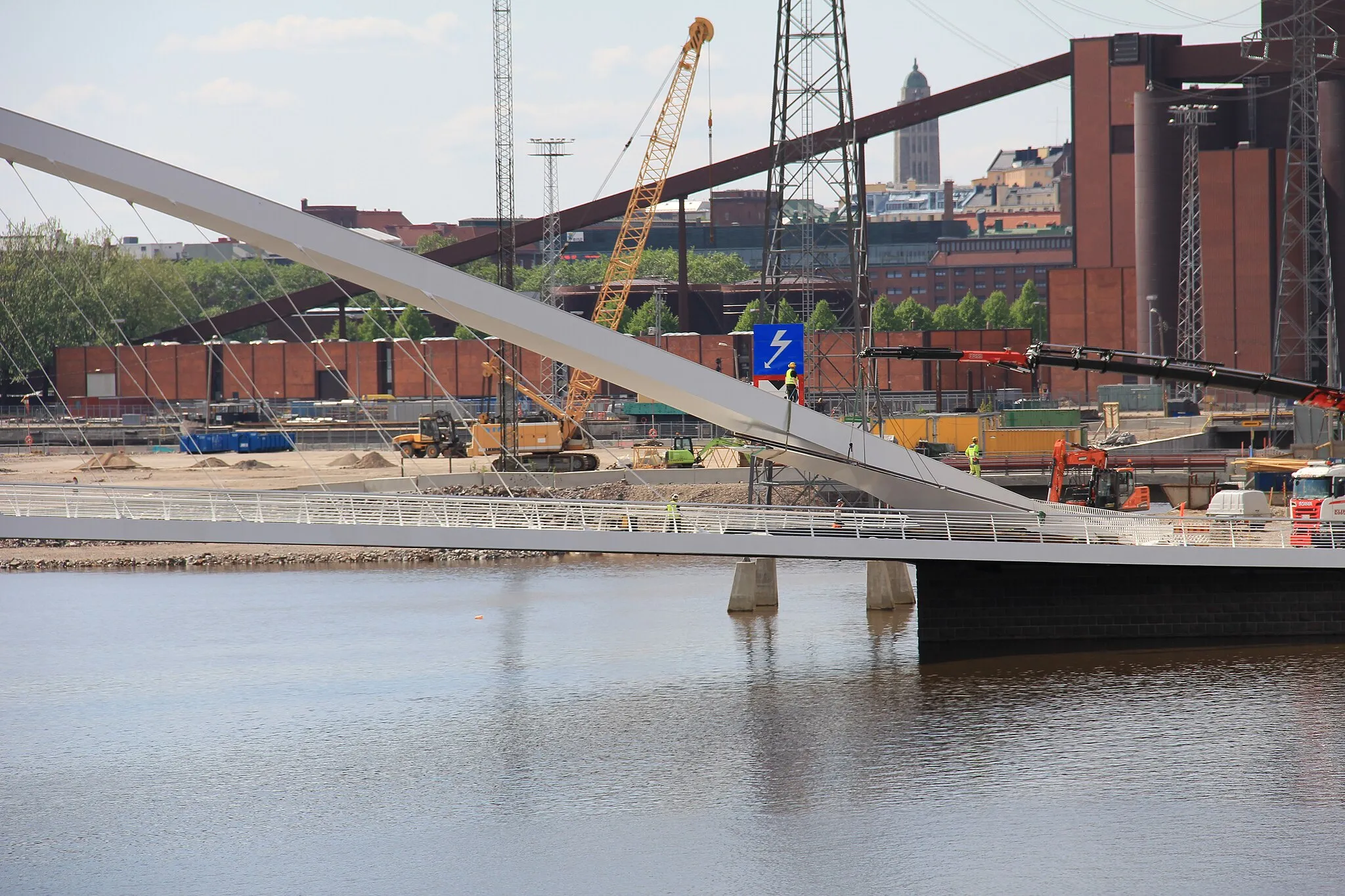 Photo showing: Isoisä bridge, Helsinki, Finland. - A Pedestrian and bicycle bridge between Kalasatama and Mustikkamaa. Seen from Mustikkamaa. -Construction workers joining arch coverings.