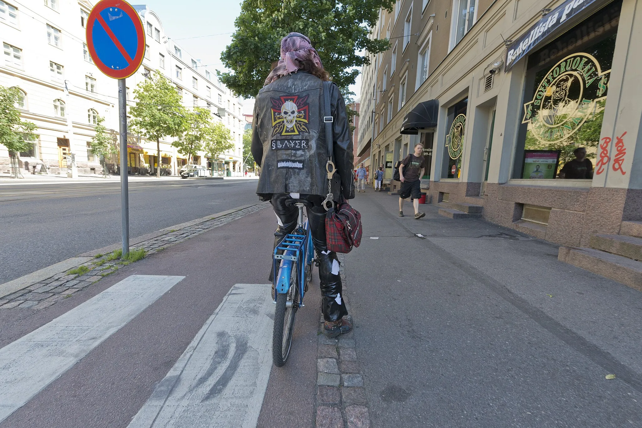 Photo showing: Metallimusiikkifani. Metallimusiikkifani Cantry Palovaara on Helsinginkadulla matkalla Tuska-festivaalille. Palovaaralle on tärkeää, että metallimusiikkifanius näkyy myös hänen ulkonäössään. Oikealla on ravintola Roskapankki. -- digitaalinen kuva, dng ja tiff, väri