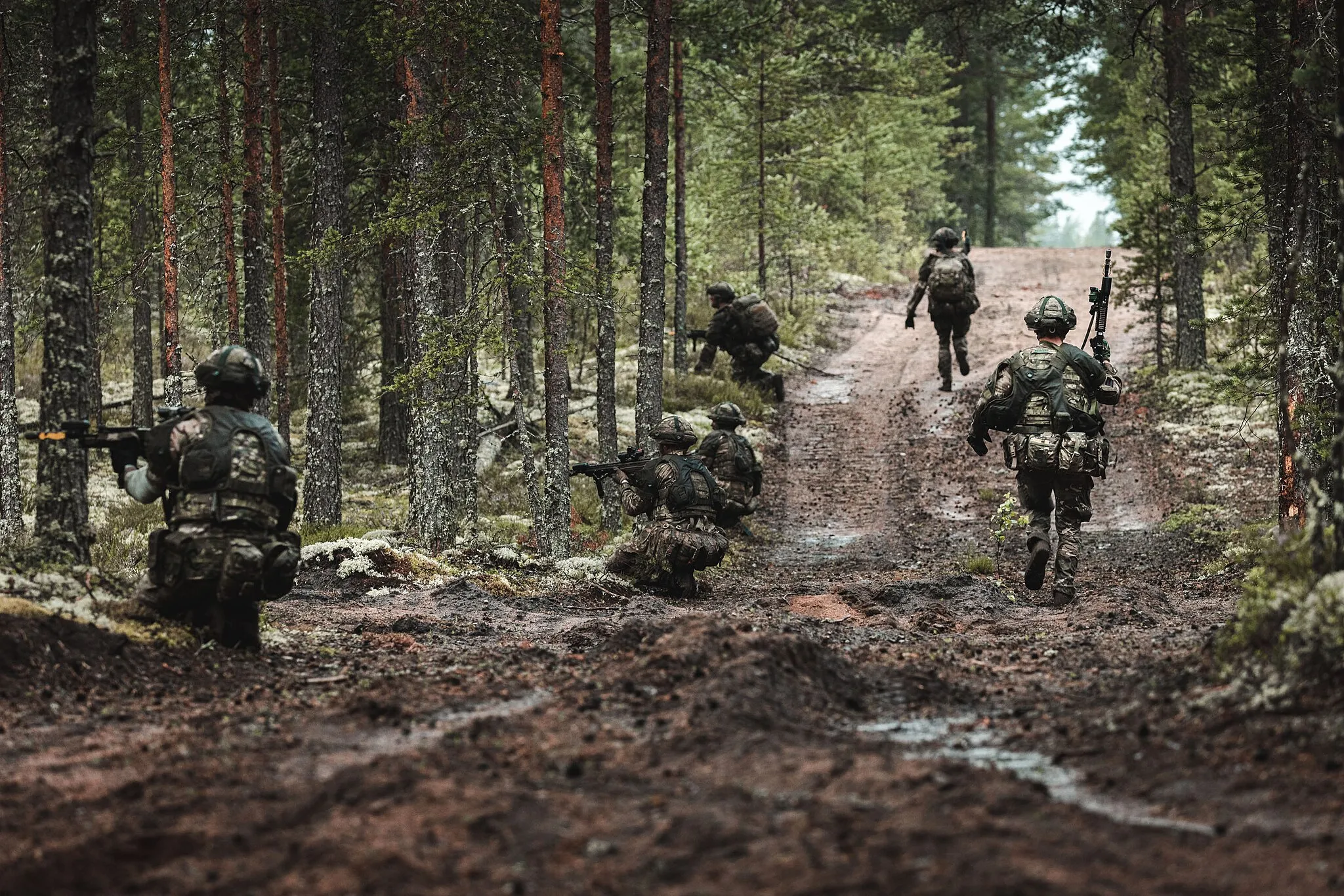 Photo showing: Soldiers from the British Army attempt to flank the enemy by running up a track with cover provided by the trees and other members of the section during Exercise Vigilant Fox in Finland. EXERCISE VIGILANT FOX is a force-on-force readiness training exercise at Niinisalo in western Finland. The exercise is intended to test the preparedness of Finland’s High Readiness Brigades whilst enhancing interoperability between Finland, UK, and US forces.Units involved in the exercise include C Company (C COY) 2nd Battalion The Rifles (2 Rifles) of the UK’s Agile Task Force usually deployed in Estonia, the Jaeger Guard Regiment (FIN), Pori Brigade (FIN) and Karelian Brigade (FIN) and a Coy of US Cavalry using the Bradley tracked fighting vehicle. The exercise also provides an opportunity to practise land-air integration as troops will be transported to the training area by RAF Chinook helicopter from C Coy 2 Rifle’s temporary base at Santahamina Island, Helsinki.