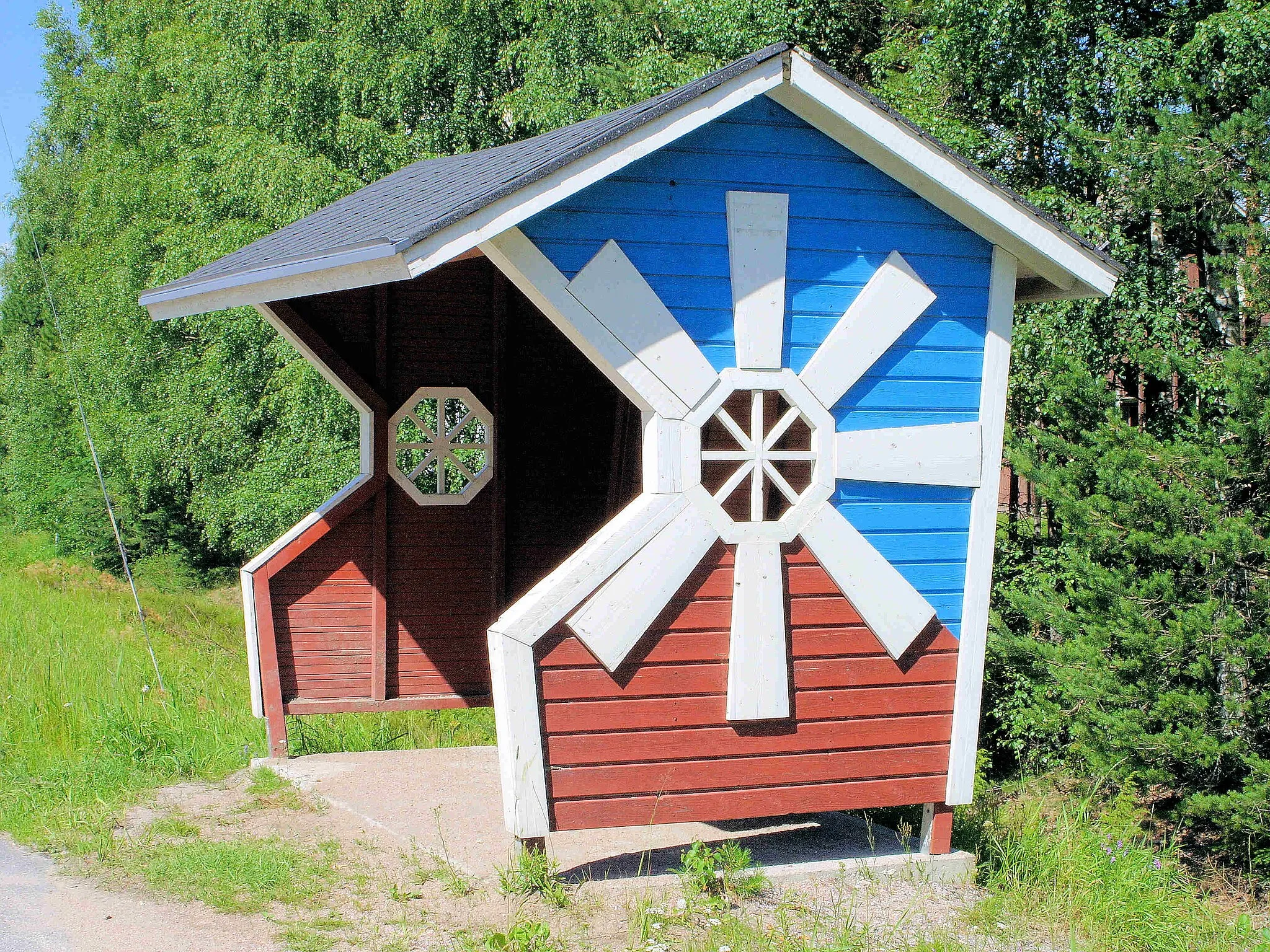 Photo showing: Bus stop shelter in Jalasjarvi, Finland Construction: A wooden bus stop shelter decorated with a wind mill theme. Wind mills are symbols of Jalasjarvi. Geographical position: N 62°23.211' E 022°48.214', Tampereentie 1122, Koskue, municipality of Jalasjarvi Photograph: Canon EOS 350D, Olli-Jukka Paloneva, 3rd July, 2007, paloneva@phnet.fi References: The municipality of Jalasjarvi (Finnish translittaration Jalasjärvi) http://www.jalasjarvi.fi