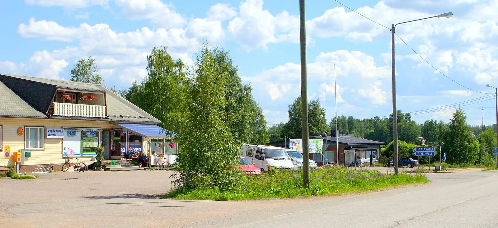 Photo showing: Koskue
Koskue is the most southern village of Jalasjarvi. The last shop of the three shops serves also as a postal services agent, which is common on the countryside as the state postal offices has been closed because of rationalisation. Many local shops function on contractual bases as post offices to serve the local people and in some cases to attract the customers, who would not probably enter the shop, if it were not a post office too.

Photograph: Samsung S850, Olli-Jukka Paloneva, paloneva@phnet.fi, N 62°21.629', E 022°50.444'