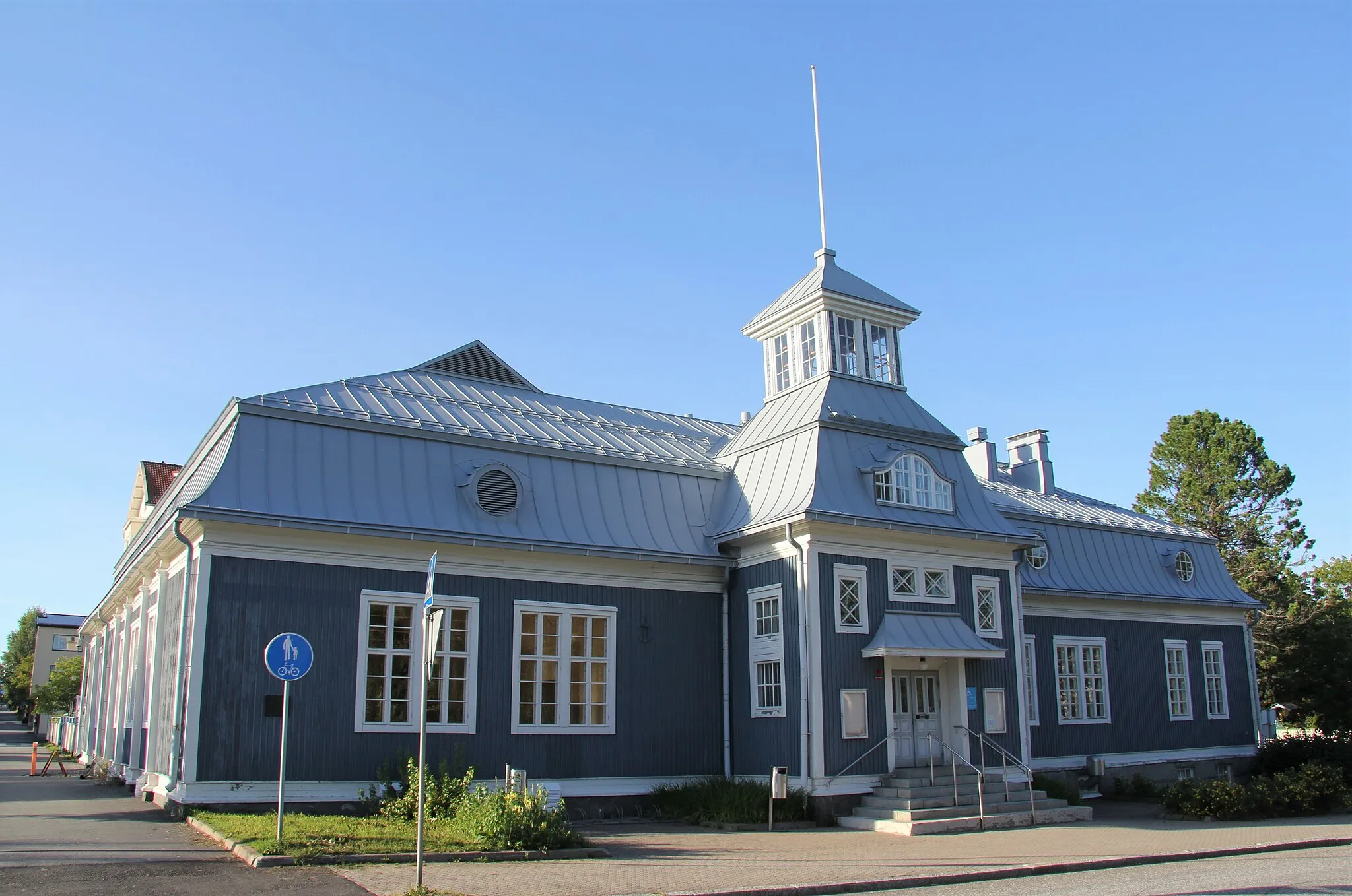 Photo showing: Iisalmen nuorisotalo on rakennus, joka oli alkujaan Suojeluskuntatalo (Laitinen, Kuosmanen, 1923). Suojeluskuntien lakkauttamisen seuraksena talo toimi vuosina 1949-1989  kaupungin  juhlasalina ja teatteritilana, kunnes 1989 Iisalmeen avattiin Kulttuurikeskus. Vuonna 1963 rakennusta peruskorjattiin ja laajennettiin sisäpihan puolelta julkisivultaan rapatulla osalla. 1970-luvulla kellaritilat muutettiin kerhohuoneiksi ja ullakkokerrokseen tehtiin biljardihuone. Nuorisotaloksi rakennus muutettiin vuonna 1989. Nuorisotalon osoite on Kirkkopuistonkatu 25, Iisalmi. Rakennuksen seinässä on suojeluskuntatoiminnasta kertova muistolaatta.
Rakennus kuuluu kulttuuriperinnöltään valtakunnallisesti merkittävän Iisalmen Kirkkoaukion ja puistoakselien itäpäätä reunustaviin, maakunnallisesti rakennushistoriallisesti, historiallisesti ja maisemallisesti merkittävien kulttuuriperintökohteiden (MA1-v002, MA1 21.102 Kirkkopuistonkadun ja Otavankadun ympäristö) joukkoon.

Kuva elokuulta 2020.