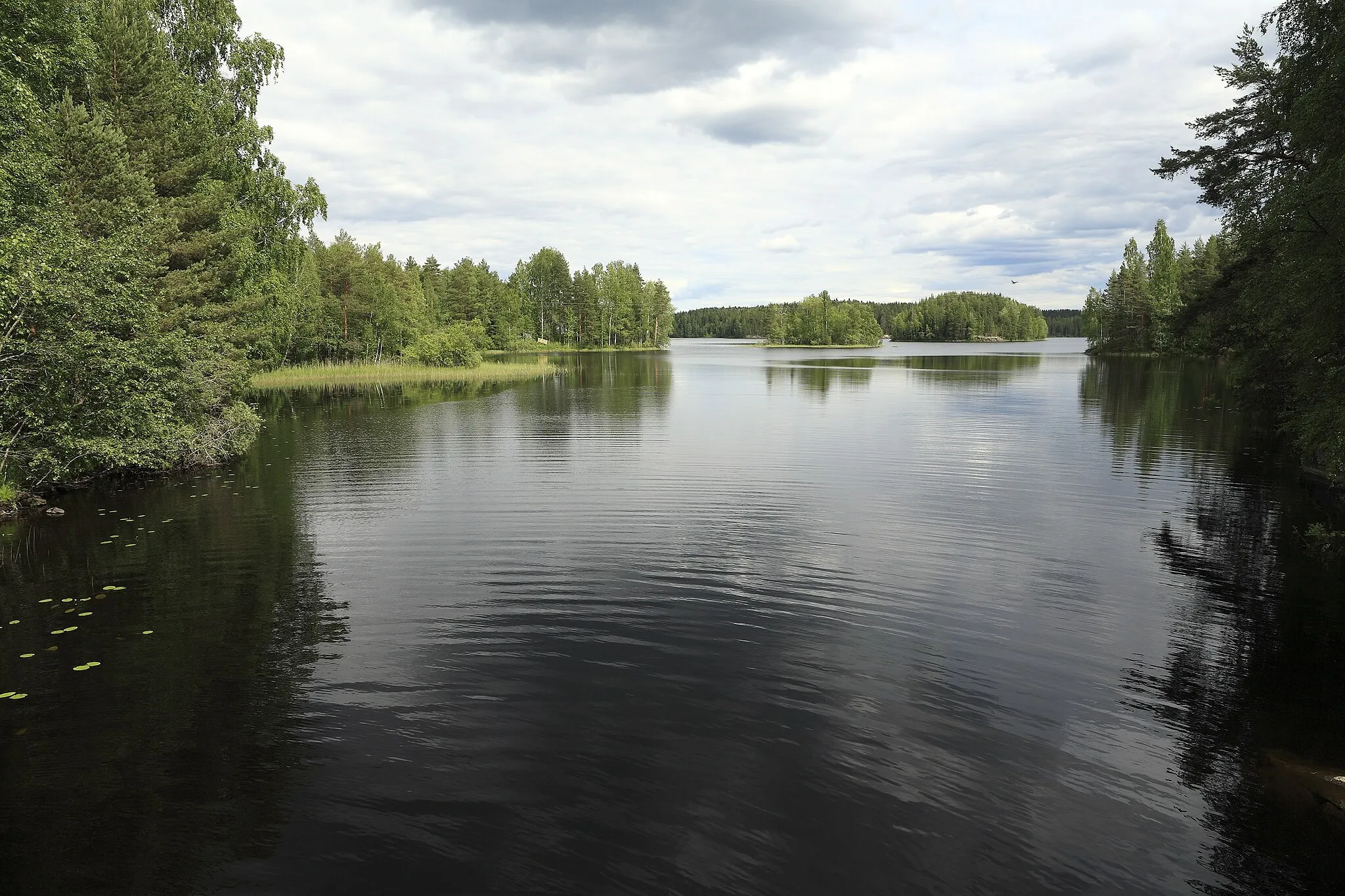 Photo showing: … oder Paunonpohja, vollig sicher scheinen sich die Kartografen bei den Namen der Seen nicht zu sein, von der Brücke zum Myhinjärvi; die größere Insel rechts im Hintergrund ist Köllinsaari.