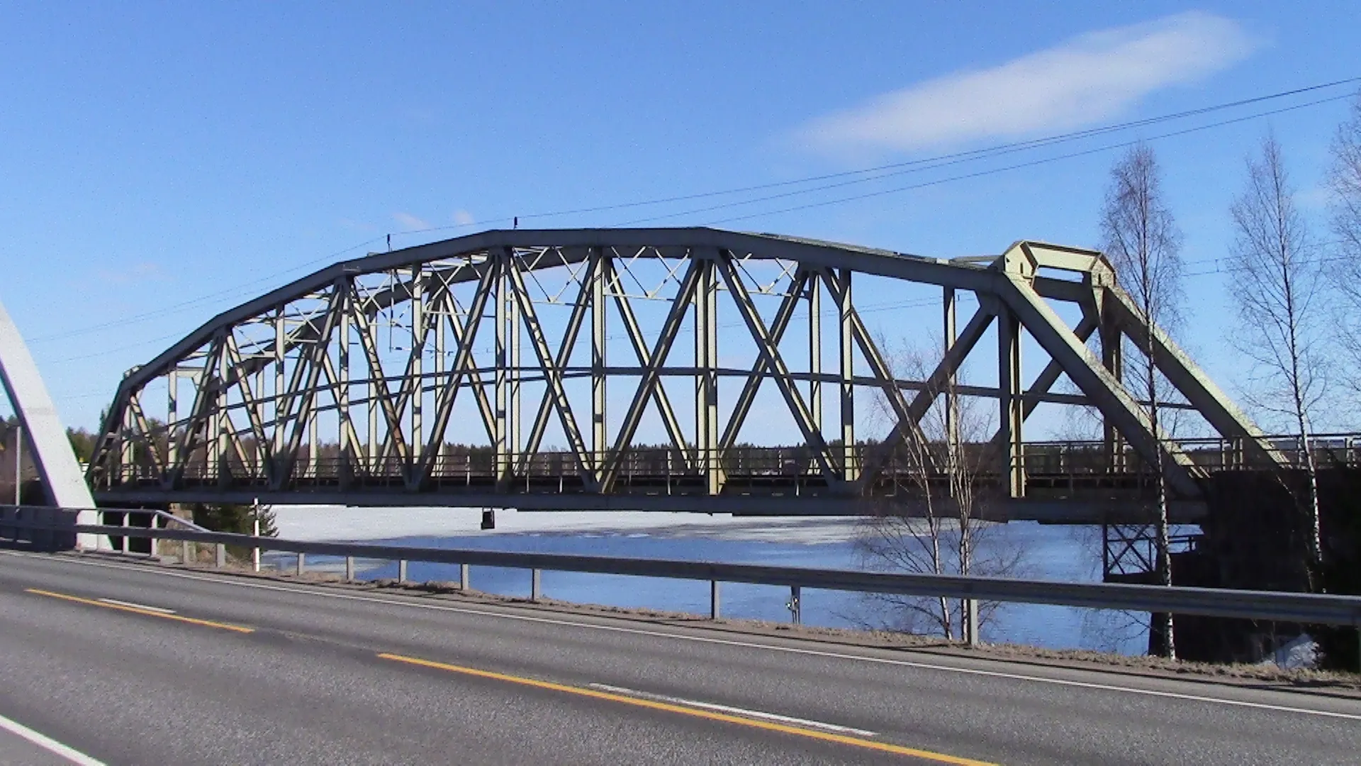 Photo showing: Railway bridge at Oulu–Kontiomäki line in Paltamo. It crosses the ending point of Kiehimänjoki river. Main road 22 in the foreground.