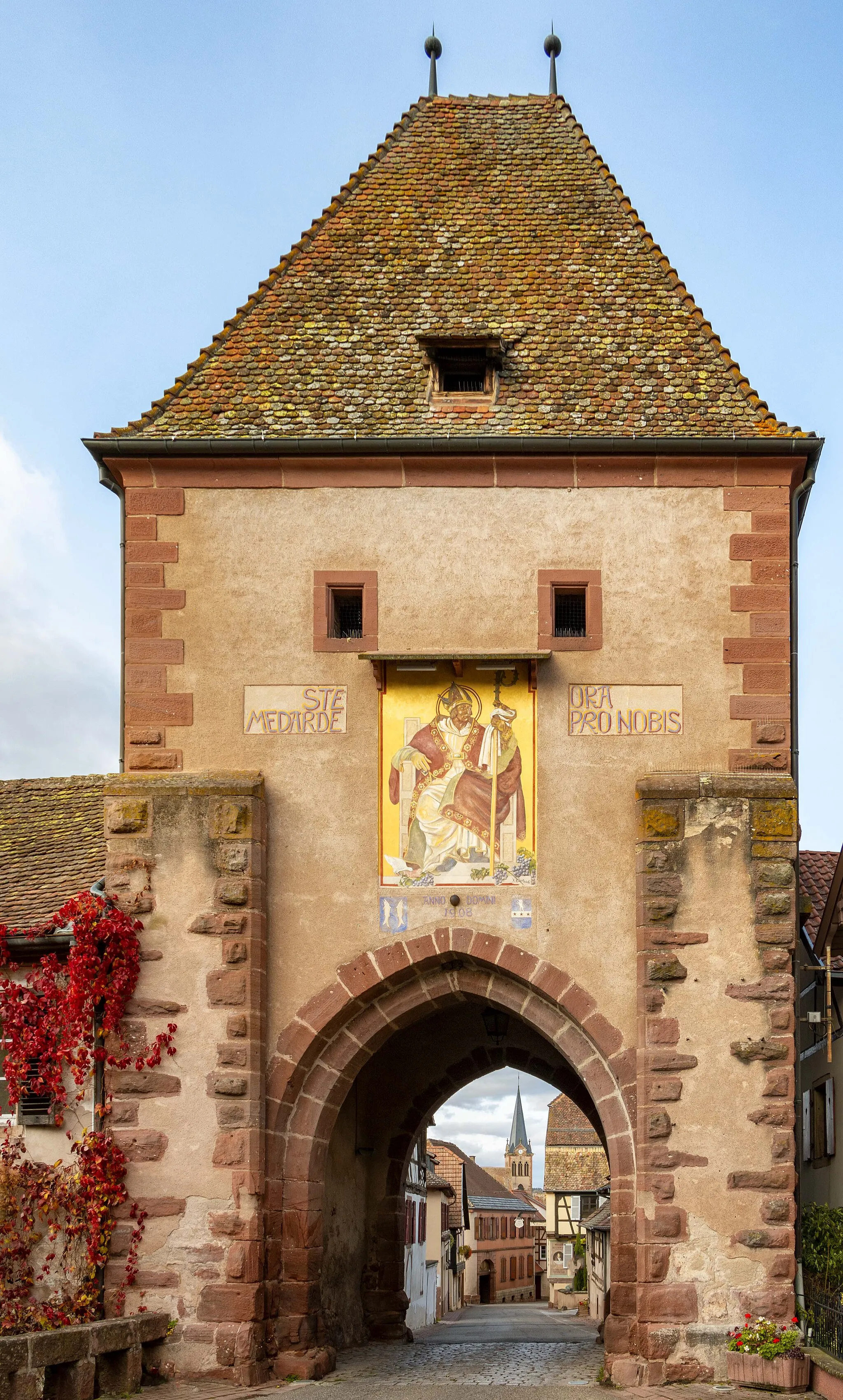 Photo showing: Bœrsch est une commune française située dans la circonscription administrative du Bas-Rhin  en région Grand Est.
La Tour-Haute, ou Obertor est située au sud de la ville. Elle a été amputée de sa partie supérieure en 1826 et n'a retrouvé son aspect original qu'à partir de 1907-1908. Elle a été décorée à la même époque d'une peinture de Dietrich représentant saint Médard, le patron de la paroisse.