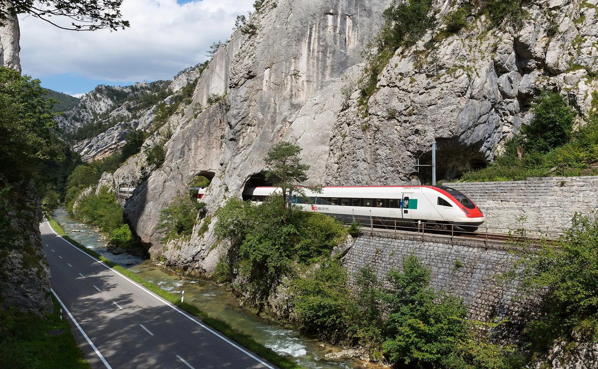 Photo showing: The Birs river, a road and a single-tracked railway line share the space in the narrow Moutier Gorge. The train is an SBB-CFF-FFS RABDe 500 "ICN" tilting train. Taken near Moutier, Switzerland.