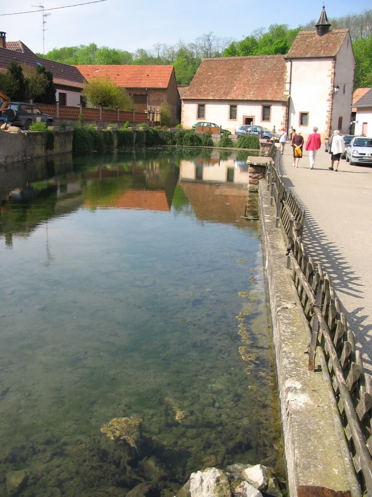 Photo showing: Kuttolsheim. Source sulfureuse utilisé par les thermes jusque dans les années 50 et comme lavoir à chevaux. Au fond, la chapelle Sainte Barbe du 13è siècle (tour) - 17è siècle (nef).