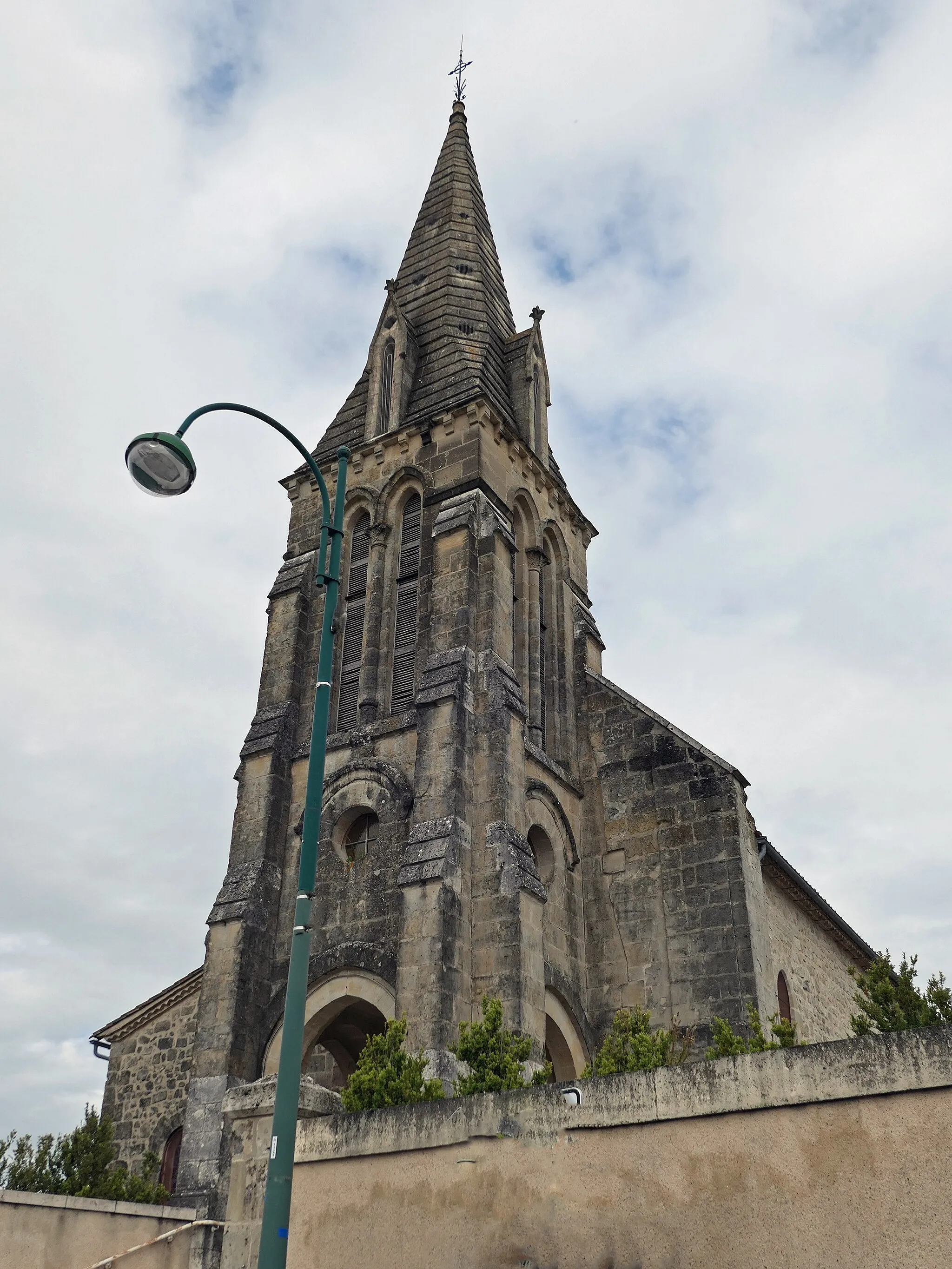 Photo showing: Eglise située en hauteur. Portail d'entrée précédé d'un escalier. Clocher surmonté d'une flèche;