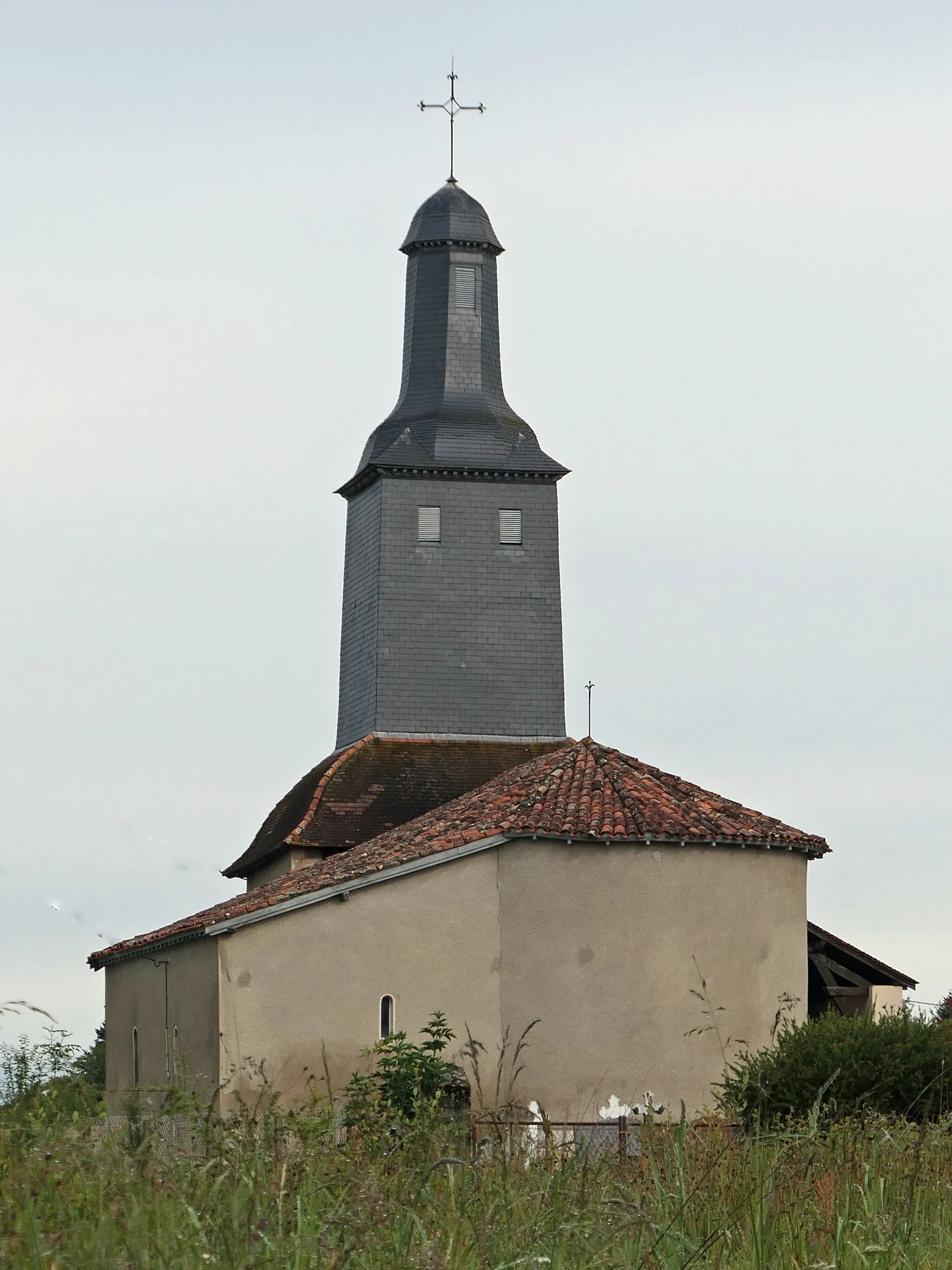 Photo showing: Petite église très simple sumintée d'un très haut clocher à plusiers niveaux couvert en ardoises