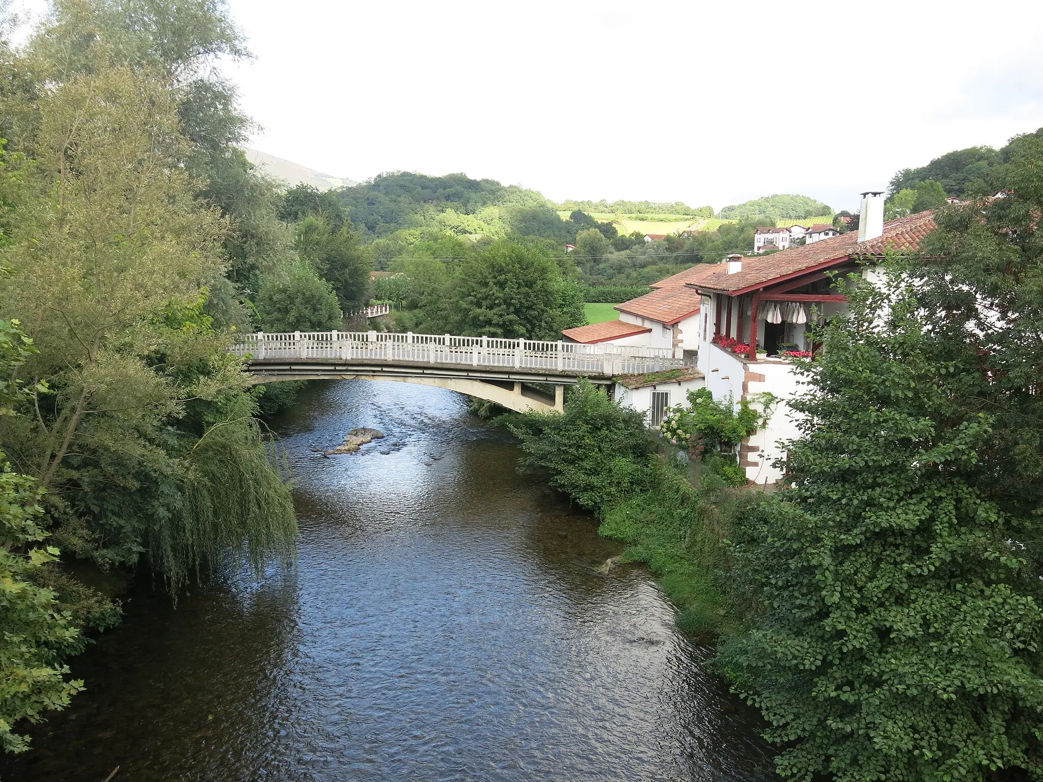 Photo showing: View downstream and to the road bridge from the roman-like bridge in Saint-Etienne-de-Baigorry (Pyrénées-Atlantiques, France).