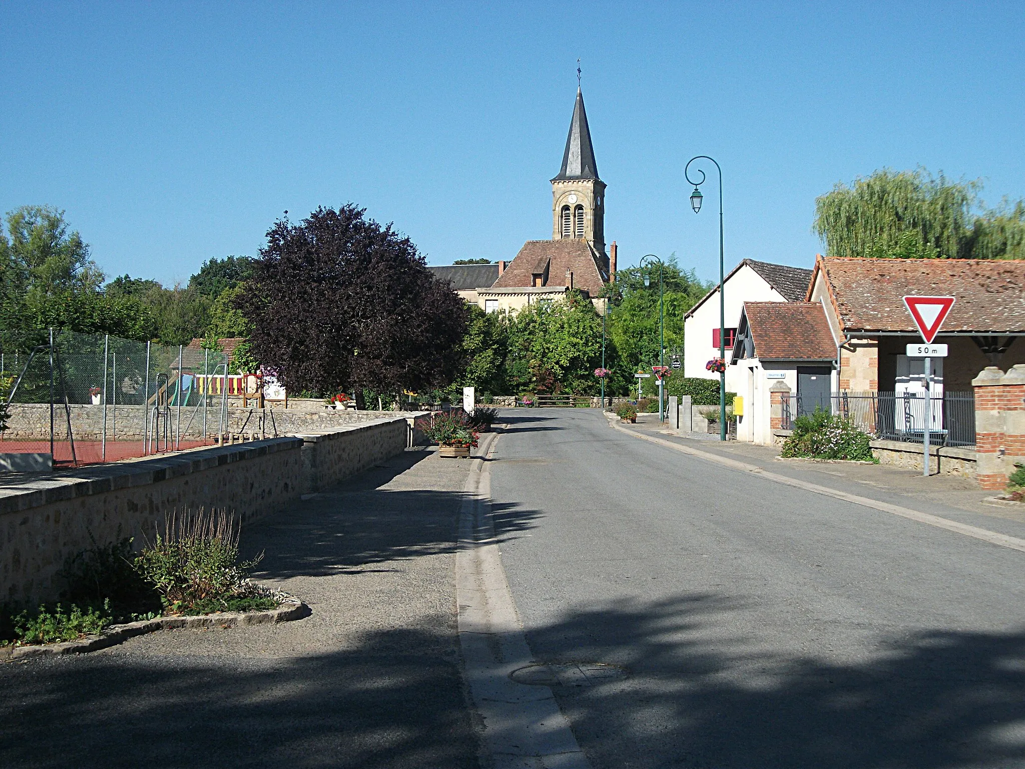 Photo showing: View of church of Saint-Aubin-le-Monial from Bourbon-l'Archambault road (rue des Écoles, D 492). [16687]