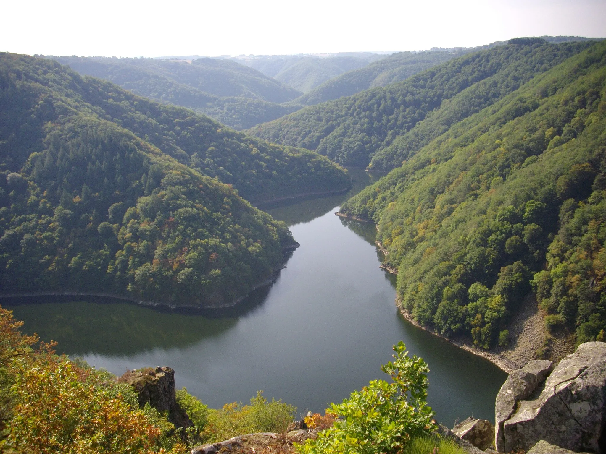 Photo showing: La Sumène (en face) se jette dans la Dordogne (au premier plan, retenue du barrage de l'Aigle) vue depuis le belvédère de Gratte-Bruyère, sur la commune de Sérandon, en Corrèze ; au second plan, communes du Cantal : Veyrières à gauche de la Sumène et Arches à droite.