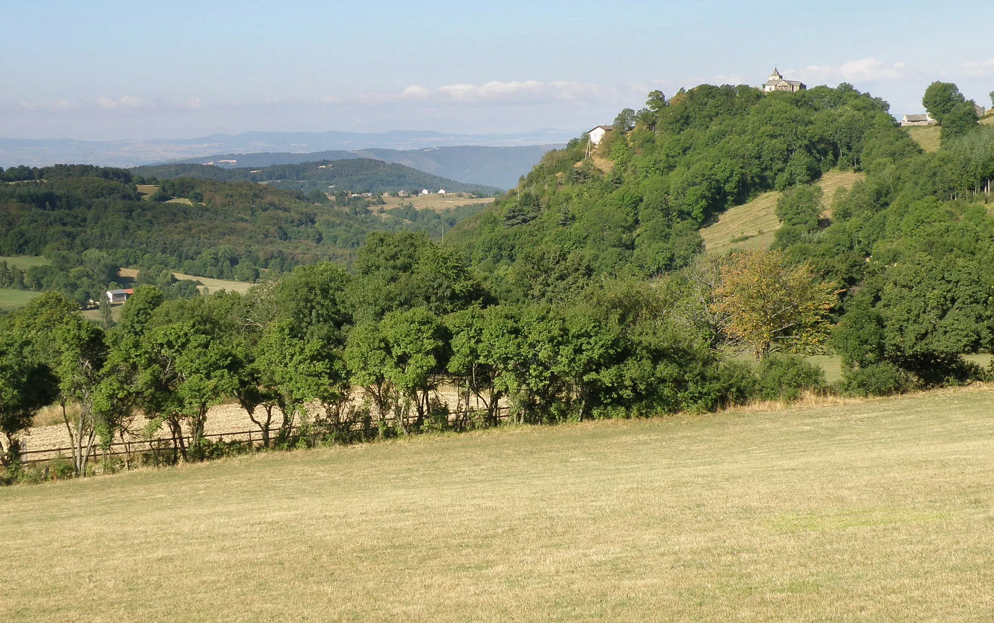 Photo showing: Commune de Saint-Julien-du-Pinet, dép. de la Haute-Loire, France (région Auvergne). 
Chapelle de Glavenas (à droite), sur son piton rocheux, à 979m d'altitude, vue depuis la D28. Coup d'oeil vers l'ouest.