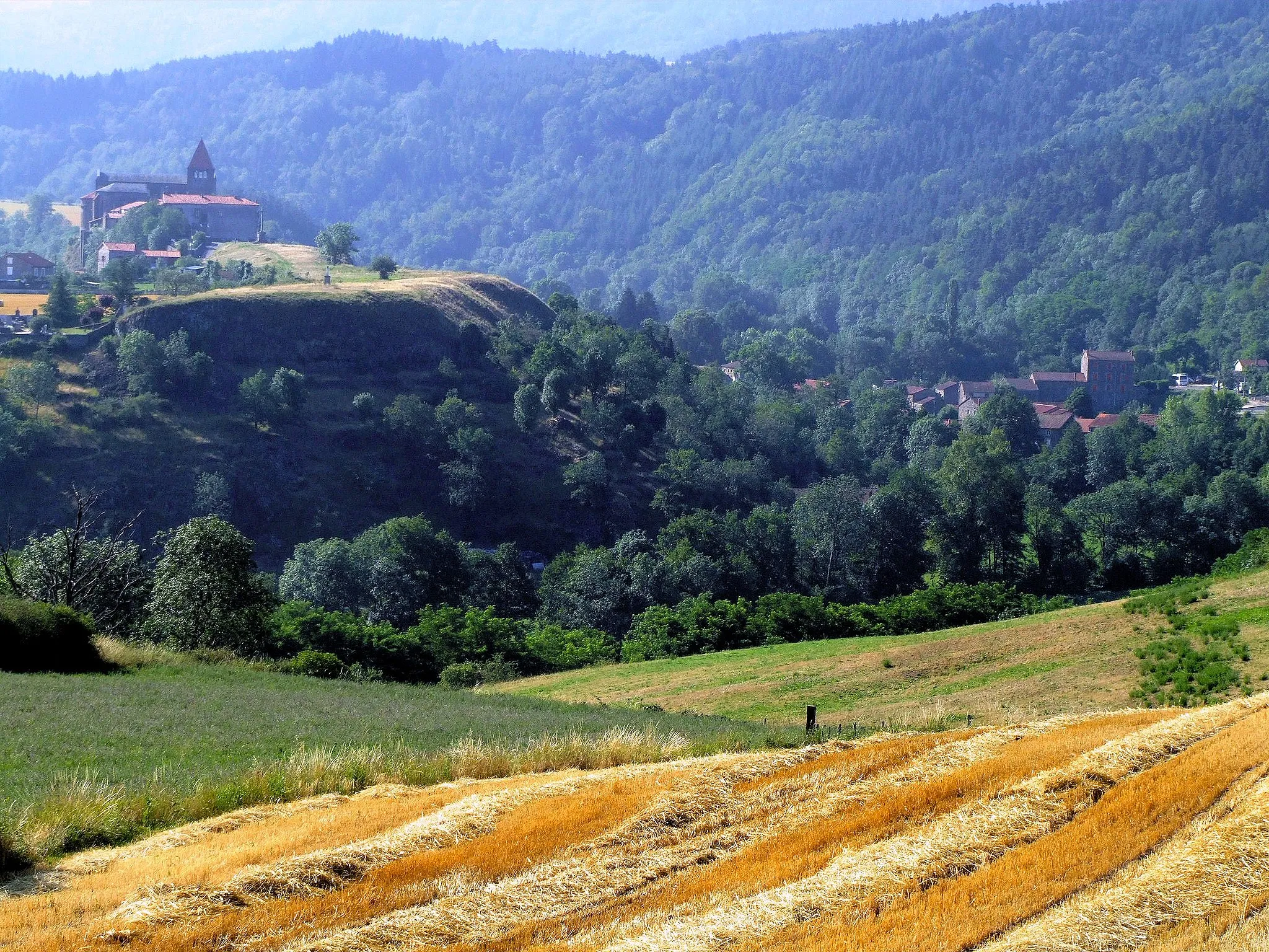 Photo showing: Chanteuges (Haute-Loire, France), seen from the north-north-west. The valley in the foreground is that of the Desges river, that runs here from right to left and reaches the left bank of the Allier river (in the "gorges de l'Allier") near the left edge of the picture. The village is perched on a height surrounded on three sides (north-east, north-west and south-west) by the two rivers.