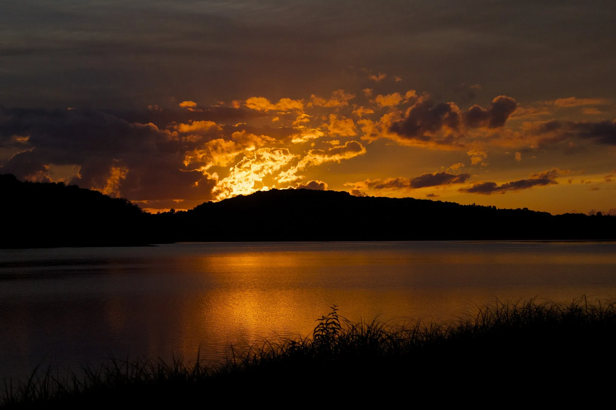 Photo showing: Un flamboyant couché de soleil enflamme les nuages au dessus du lac de Pennecière.