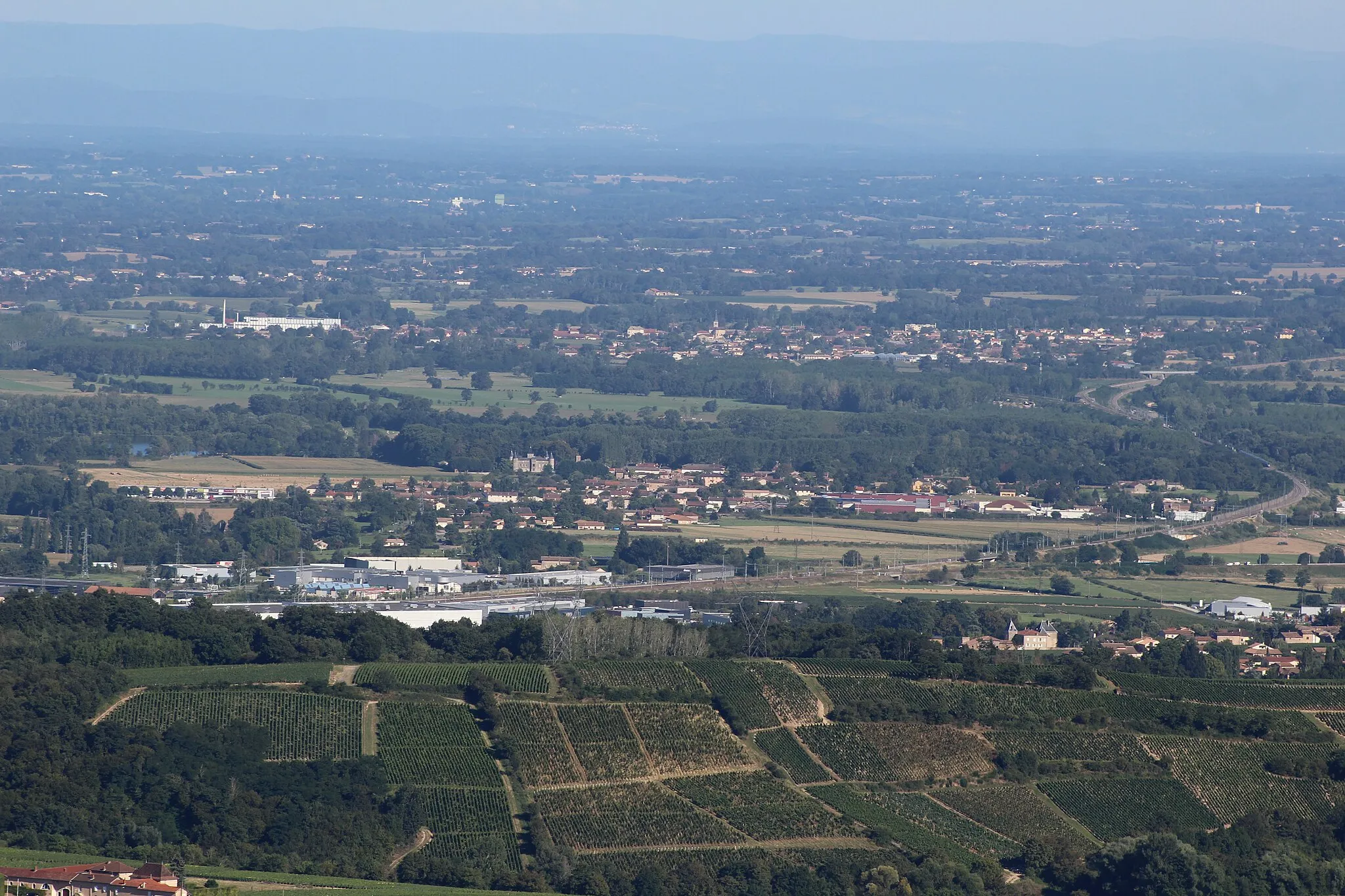 Photo showing: Vue sur la Bresse et le Mâconnais, plus précisément Varennes-lès-Mâcon où le château de Varennes est visible.
En second plan, Grièges et sa laiterie sont visibles.
La ligne LGV Sud-Est traverse devant Varennes.

La photo a été prise au sommet de la roche de Solutré.