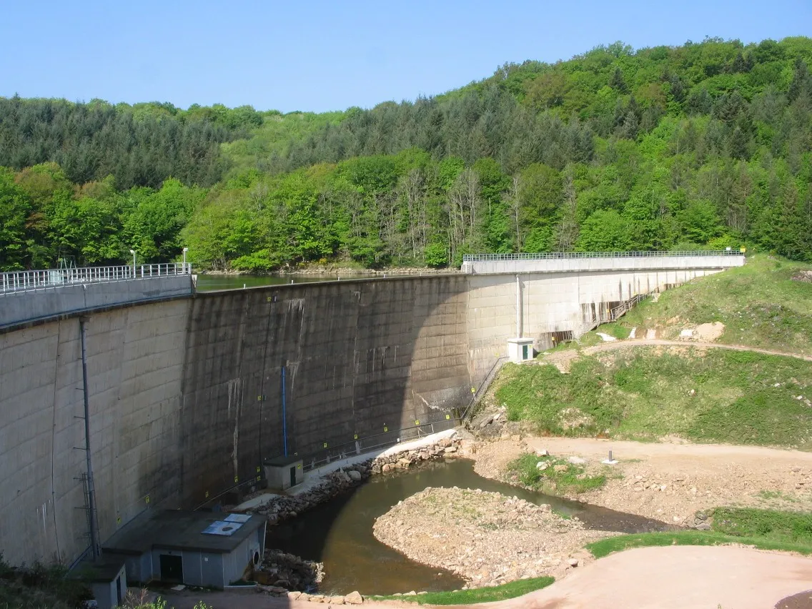 Photo showing: Barrage du Pont du Roi à Tintry, Saône et Loire.
Erigé entre 1957 et 61 cet ouvrage, haut de 23 m pour une longueur de couronnement de 197 m, propriété du conseil départemental, fait l’objet d’un suivi renforcé et travaux au milieu des années 2010 visant à accroître sa longévité.

De type voûte mince en béton, le mur est conçu pour faire face à des débordements sans dommages à l’environnement extérieur en cas d’intempéries, ce qui permet d’assister à des scènes parfois spectaculaires lors de fortes précipitations sur une longue durée...