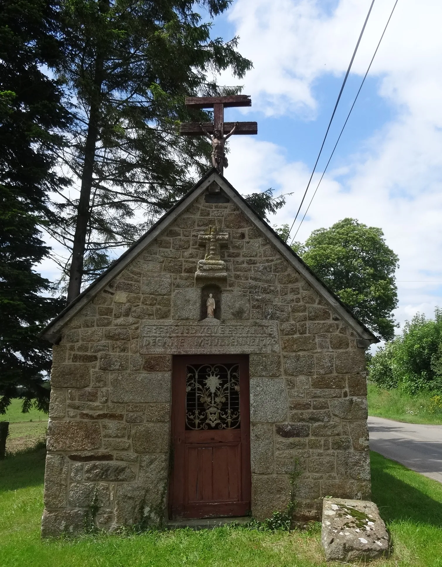 Photo showing: La Chapelle Chêne-Jouanne se situe au bord d’une petite rue de campagne, au lieu dit « Le Petit-Aussé. Il est en granit, sur le linteau il est inscrit  la date de construction (1790) ainsi que les noms des constructeurs et des propriétaires. Dessus il y a une croix portant le Christ en rouge de Pontmain s’élevant derriere la Chapelle.