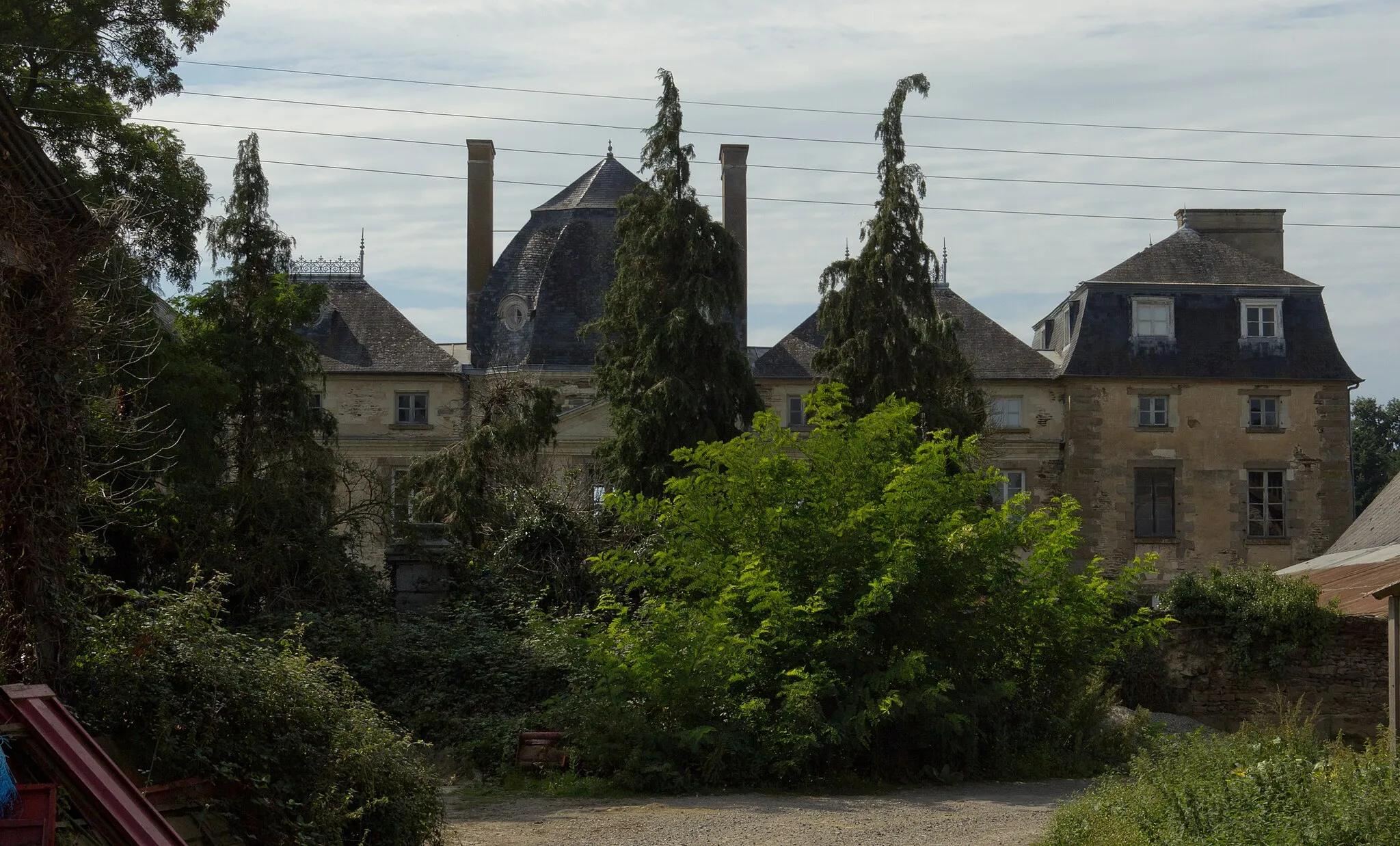 Photo showing: Le château est masqué par son mur d'enceinte et la végétation (au premier plan). Le fronton triangulaire et le toit en dôme du pavillon central sont visibles en arrière-plan, ainsi que les deux corps de bâtiment et un pignon de l'aile nord.
Notice n° PA00090516