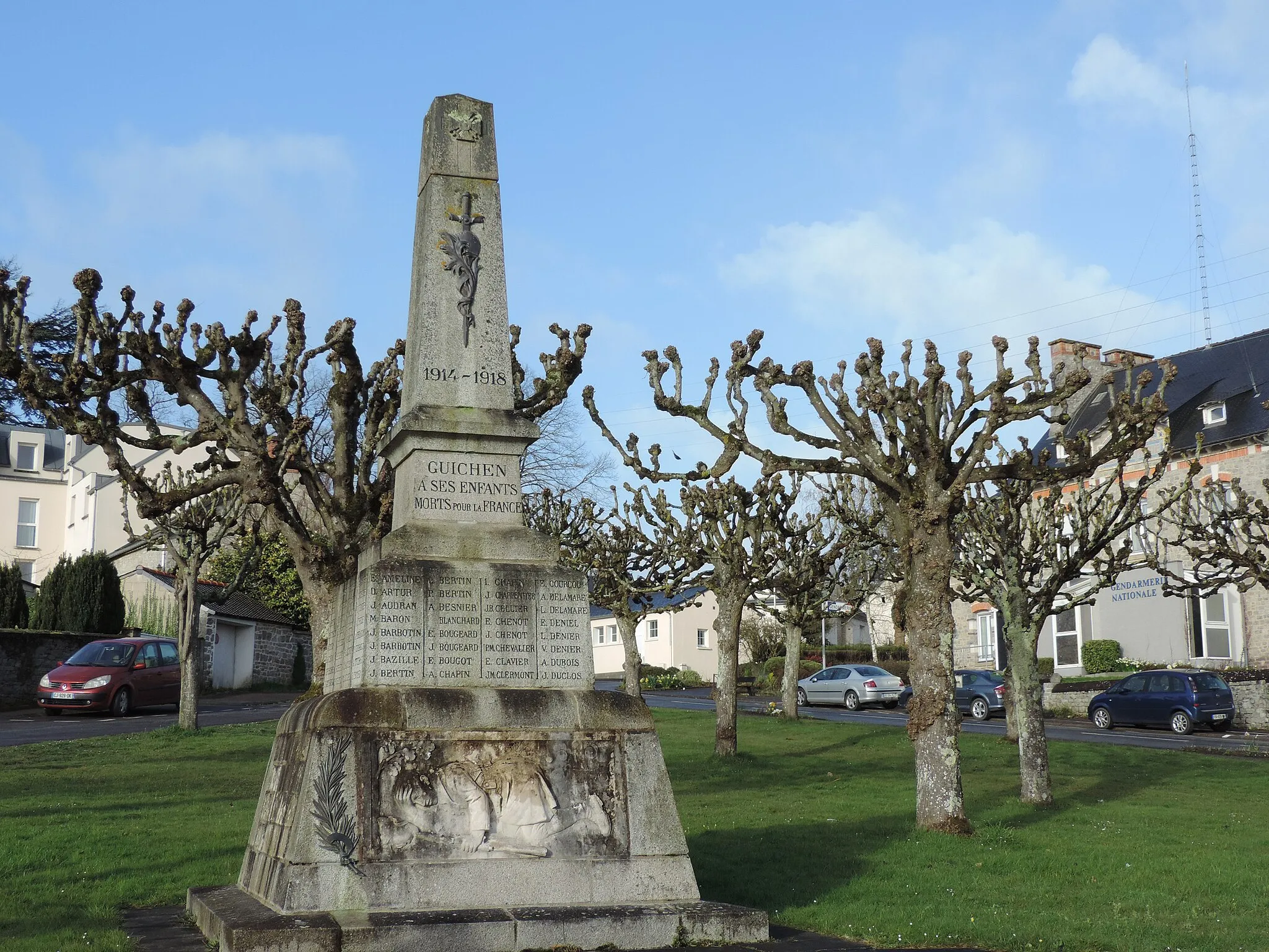 Photo showing: War memorial of Guichen, in Georges-le-Cormec Square. Office of the National Gendarmerie behind.
