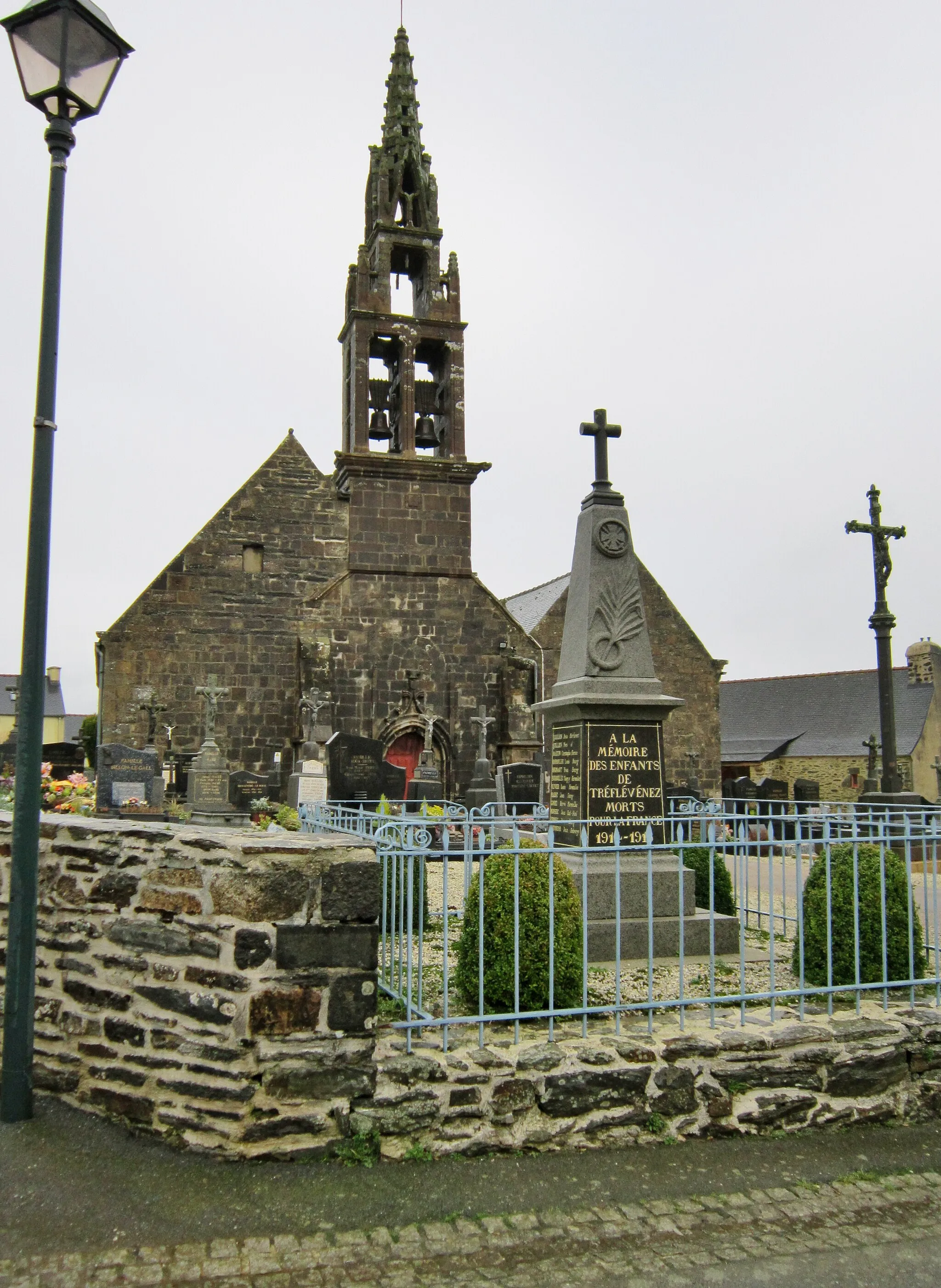 Photo showing: Tréflévénez : l'église paroissiale Saint-Pierre et le monument aux morts.