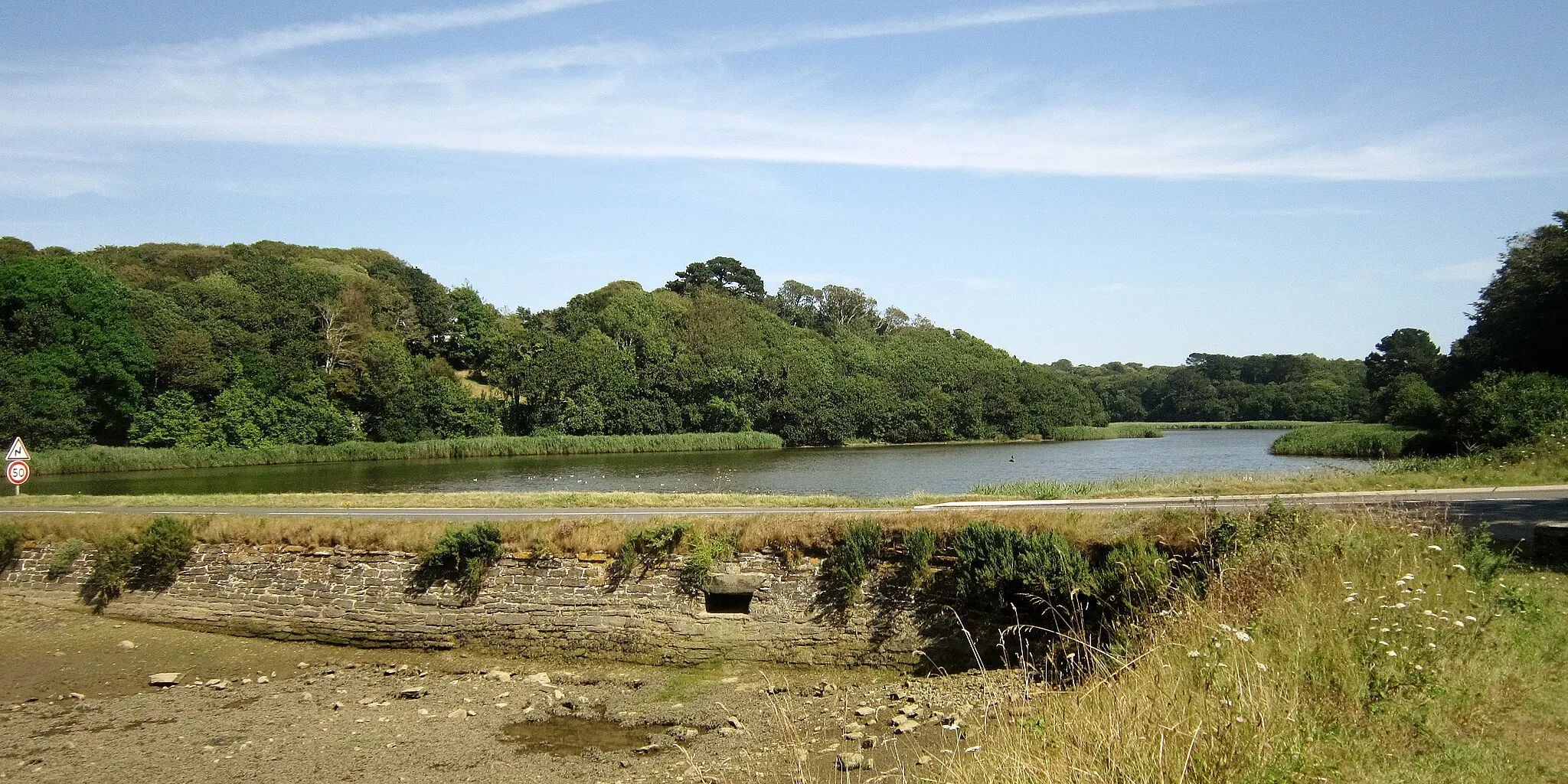 Photo showing: L'étang de Kerjean au fond de la ria du Conquet ; au premier plan la digue retenant les eaux de l'étang et qui porte la route départementale D 28.