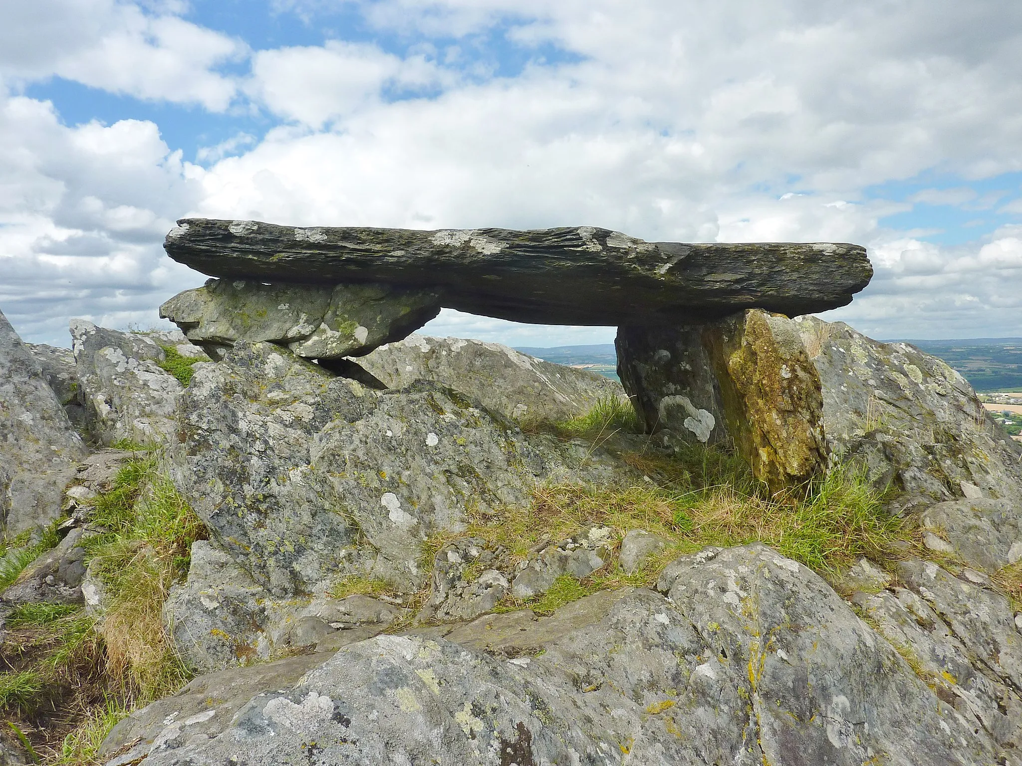 Photo showing: Gouézec : grosse pierre de schiste, faisant penser à un dolmen, reposant sur trois pieds, au sommet de la "Roche-du-Feu" (Karreg-an-Tan), un des sommets des Montagnes Noires. Depuis toujours, les gens gravent sur cette pierre et autour, leur nom ou y font des dessins, ce qui montre bien l'attachement qu'ont les personnes pour cet endroit.