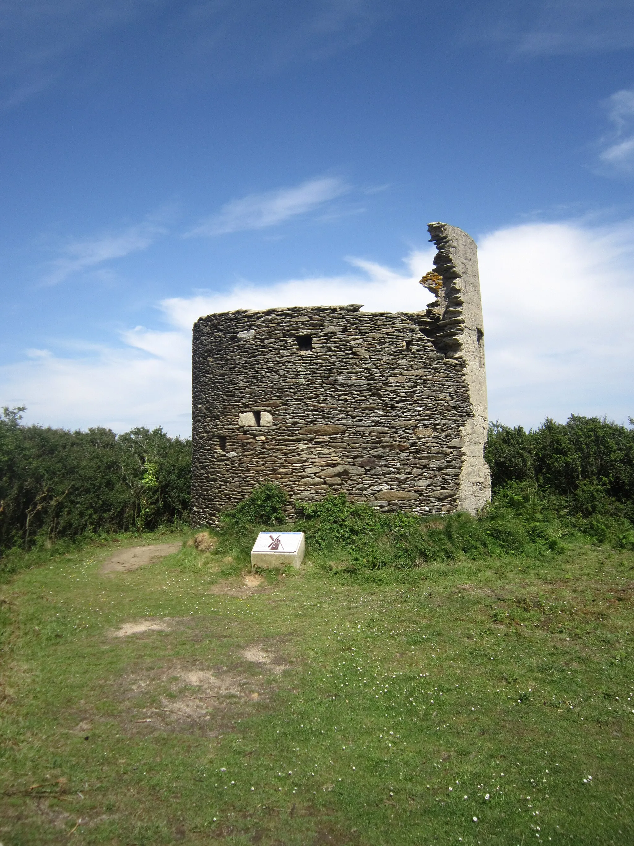 Photo showing: Les restes de l'ancien moulin à vent de Ruvras (Ru Vraz). Ce moulin, dont la présence est attestée au début du XIXe siècle, est le dernier encore visible parmi les trois qui existaient dans la commune. Il a perdu ses ailes en 1856, mais sa silhouette trapue a continué de servir de repère aux marins. En 1940 il fut consolidé, armé et transformé en poste d'observation par les Allemands.