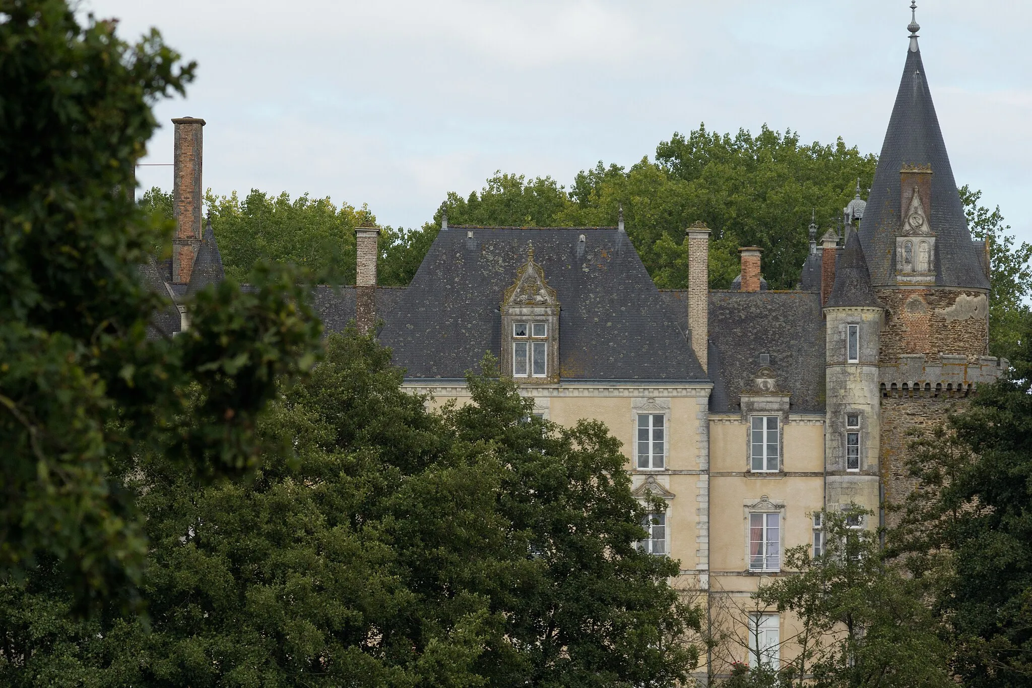 Photo showing: Argentré-du-Plessis (Ille-et-Vilaine, France) : Le château du Plessis ; la tourelle de briques forme l'extrémité de l'aile est du château. Le toit de la chapelle est visible derrière celui de la tourelle.
