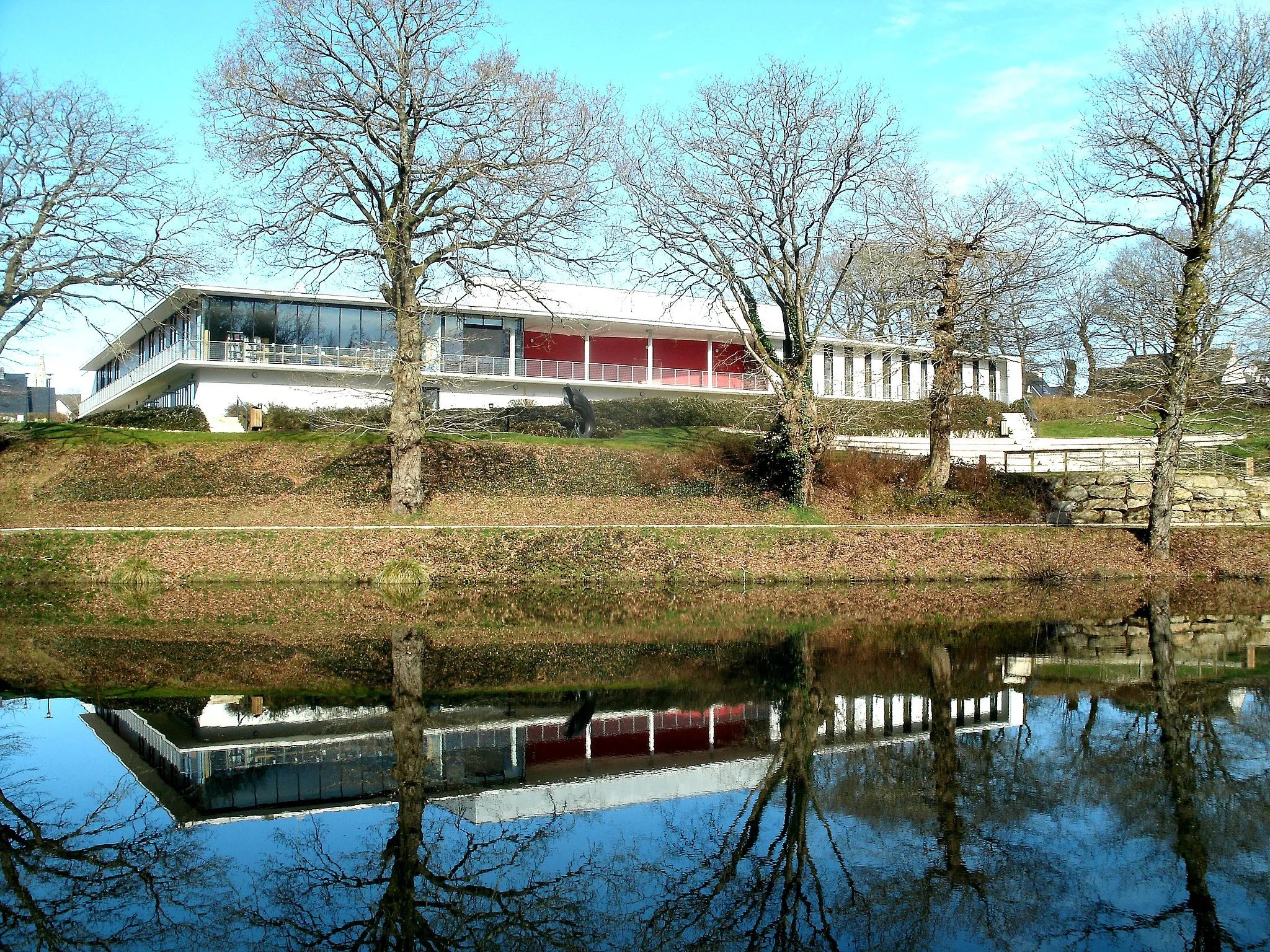 Photo showing: Façade sud de l'Espace des médias et des arts de Languidic ; au premier plan, l'étang de Poulvern.