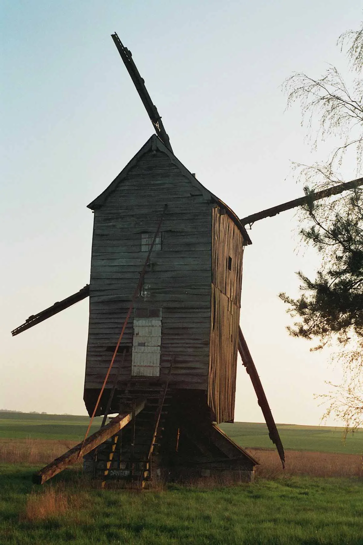 Photo showing: Wooden windmill seen backwards on the Beauce plain with a few tree branches on the right