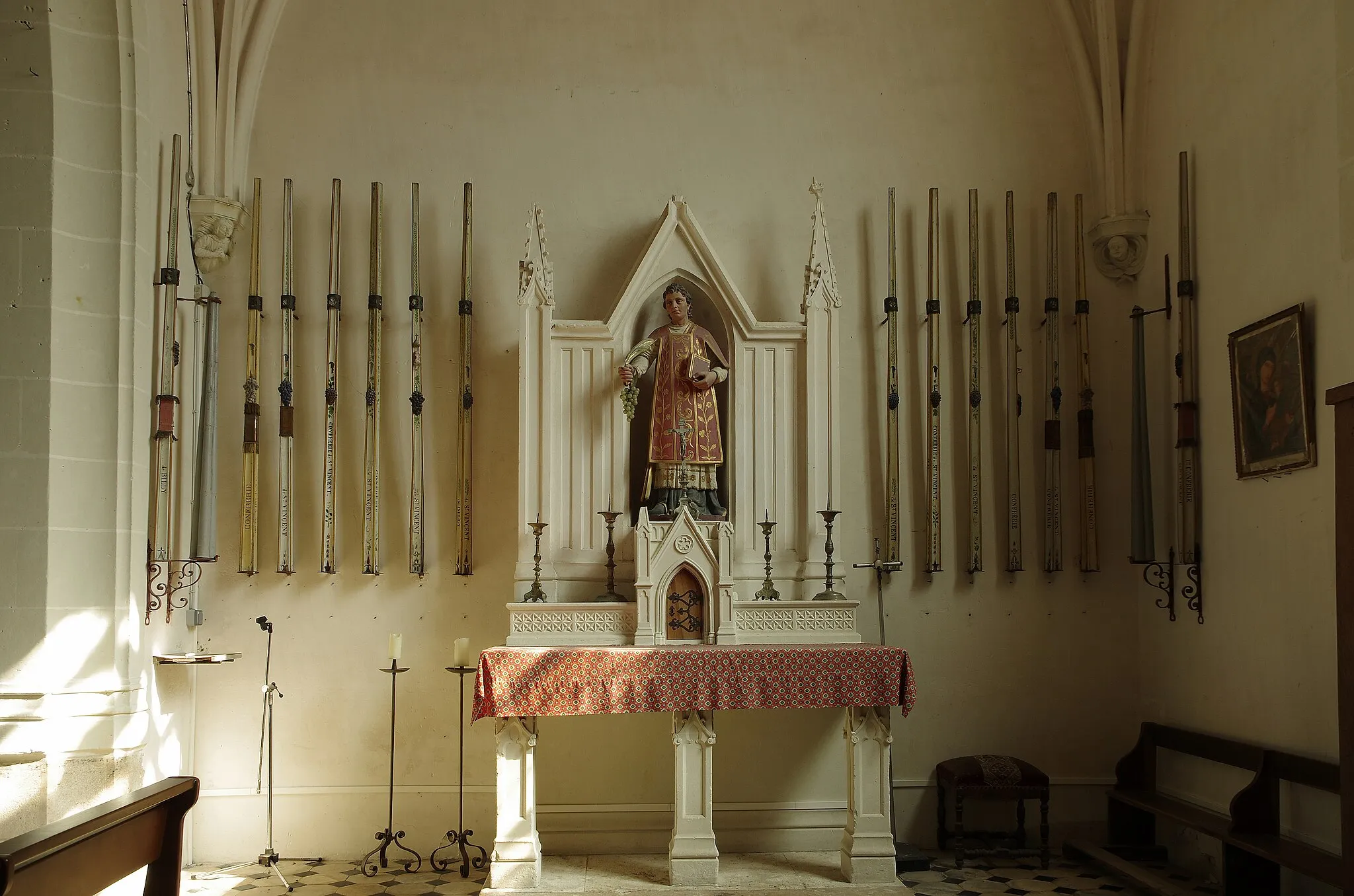 Photo showing: Billy (Loir-et-Cher)
Eglise Saint-Symphorien. La chapelle sud.
La nef, la partie la plus ancienne, construite en petit appareil, a été édifiée au XIe siècle. Le clocher, tour carrée sur la façade sud, a été rajouté au XIIIe siècle; l'accès à l'étage se fait par une tourelle externe avec un escalier à vis. Le choeur et l'abside seront reconstruit à la fin du XVe siècle. Les vantaux du portail seraient du XVIe siècle, le portail sera refait dans la seconde moitié du XIXe siècle. Des chapelles latérales, formant transept, sont ajoutées au XXe siècle. Une porte méridionale* a été murée.
Des petits personnages sont sculptés sur la façade occidentale, au dessus du portail.
A l'intérieur, sur le mur nord, un fragment de peintures murales, du XVe siècle, subsiste. De gauche à droite :
Saint Blaise nu, martyrisé par deux bourreaux avec des peignes à carder.
Sainte Catherine, près de la roue de son supplice, couronnée et qui tient une épée.
Sainte Barbe tenant une palme et un livre, aux côtés de sa tour.
Sur le mur nord, toujours, une épitaphe, en caractères gothiques, à la mémoire du prieur Pierre de Villède, mort en 1511.
Dans la petite chapelle sud, une série de quatorze cierges de la confrérie de saint Vincent, en zinc, du XIXe siècle.

Une archive mentionne le don de l'église par Childebert Ier* au prince Vulphin* pour l'abbaye de Selles-sur-Cher.
En 1128, après qu'elle fut usurpée par des laïcs, son dernier possesseur Hugues Graflutz la remet à Jean II évêque d'Orléans qui l'attribue à l'abbaye de Selles-sur-Cher; un prieuré-cure y est alors créé.
Au 15e siècle, un prieuré existait à Billy. Sous François Ier, l'église fit partie du domaine de la couronne jusqu'à la disparition du roi.

C'est à la porte méridionale de l'église que se faisait la purgation canonique. Les juges ne pouvant établir suffisament les faits d'un crime, ordonnaient que l'accusé soit conduit à la porte méridionale de l'église pour y prêter serment, devant la population, qu'il était innocent.  Les portes méridionales des grandes églises ont souvent de vastes portiques qui rendaient les serments plus spectaculaires. Childebert Ier est le quatrième fils de Clovis. A la mort de son père, le royaume est divisé en quatre et Childebert devient roi des francs de Paris. Après la mort de son frère Clodomir, il devient également roi des francs d'Orléans. Vulphin (Wulfin), puissant seigneur de sang royal, avait accompagné Childebert Ier en Espagne, dans une expédition guerrière contre les Wisigoths. En 542, il prend l'habit dans l'abbaye royale de Celles (Selles-sur-Cher). Wulfin donna une grande partie de ses terres et des églises, en particulier celle de Billy qui dépendait du diocèse d'Orléans. www.culture41.fr/Annuaire-culturel/Patrimoine/Edifices-re...

Bulletin Monumental publié par M. de Caumont- 1845.