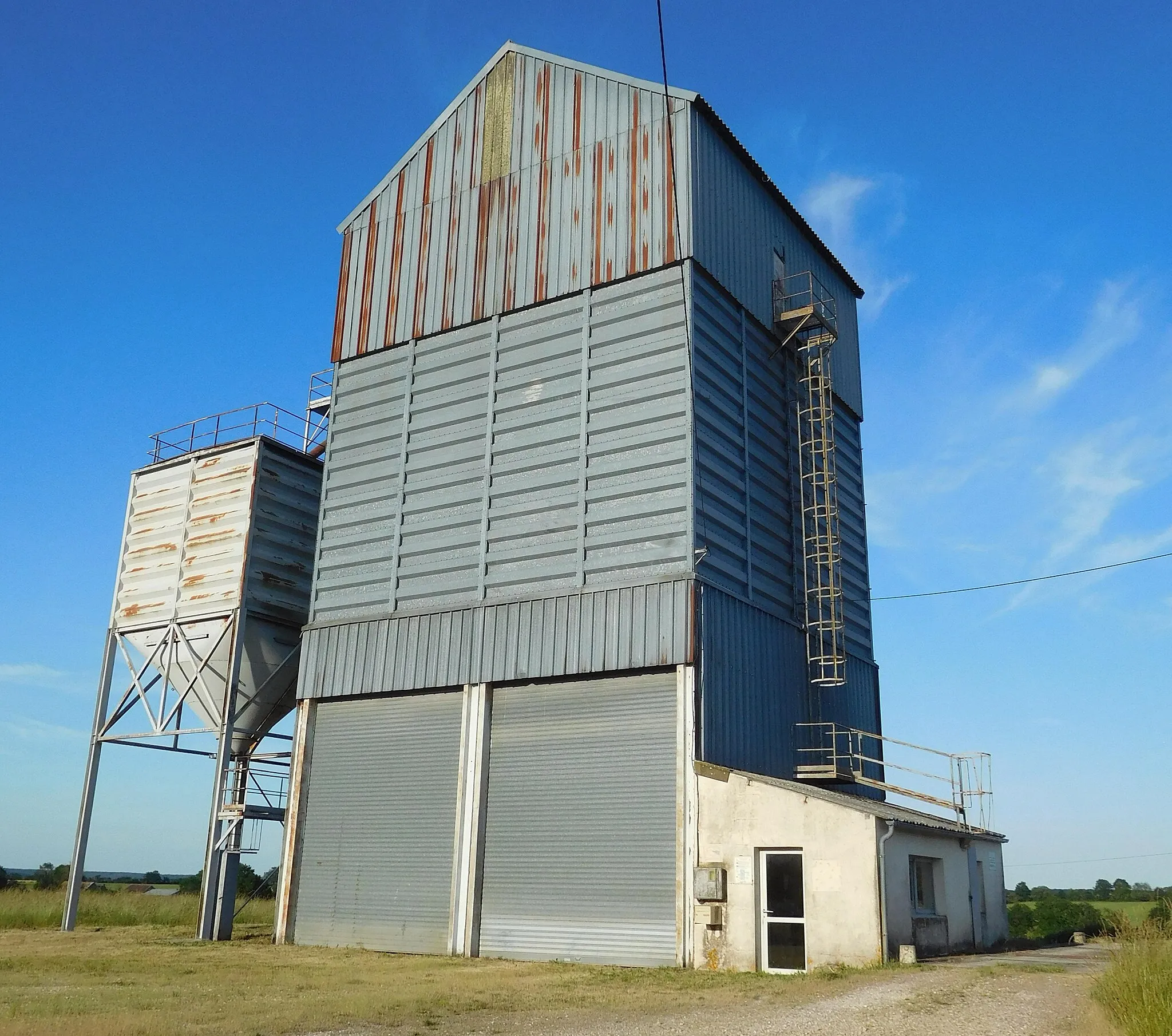 Photo showing: Silo céréalier (recouvert de tôle ondulée) Axéréal, laboratoire et pont-bascule (à droite) ; La Pierre Aiguë, Annay, Nièvre, France.