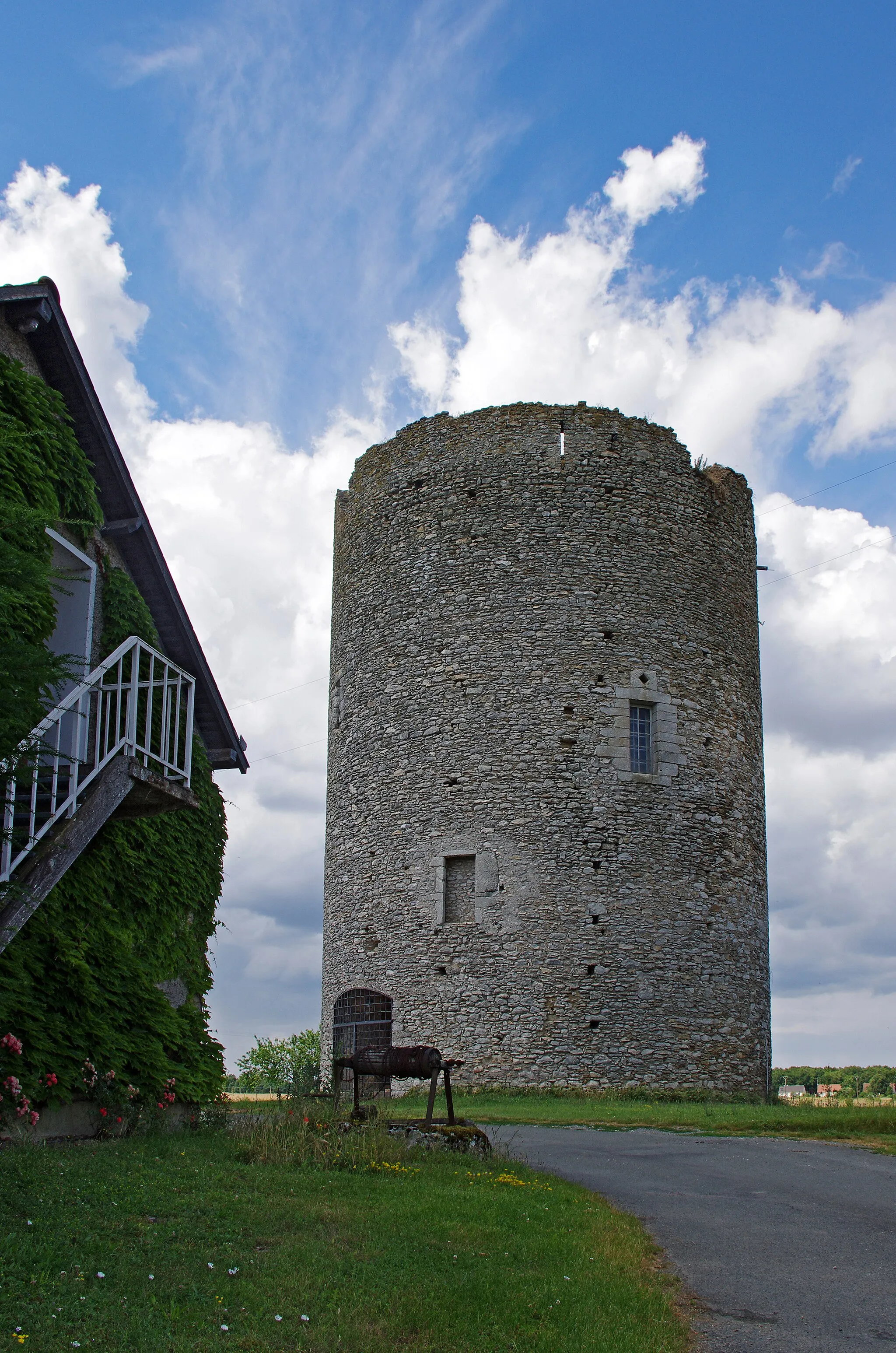 Photo showing: Athée-sur-Cher (Indre-et-Loire)
La tour du Brandon.
La tour semble avoir été édifiée au XIIème siècle.  Elle occupait à peu près le centre d'une enceinte fortifiée de de 45 à 50 ares. La muraille fortifiée, de 1,40 m d'épaisseur était elle même entourée par des fossés.
La muraille existait encore en 1583, ainsi que l'indique un aveu* du 25 juillet 1583, par Louis de Rohan , seigneur de Montbazon.  Dans le même aveu*, on apprend que la tour avait été "depuis longtemps ruynès en partie par les Anglais".
La muraille d'enceinte a aujourd'hui disparu, sauf quelques éléments inclus dans une construction récente.
Au mois de juin 1846, des ouvriers, en faisant des fouilles dans le voisinage de la tour du Brandon, ont mis à découvert un squelette étendu sur un banc de roc. En recueillant les ossements, on a trouvé parmi eux trente-trois pièces de monnaies d'empereurs romains Marc-Aurèle, Commode, Antonin le Pieux, et autres.
Le premier seigneur connu du Brandon est Guillaume de Brandon (Guillelmus de Brandone) mort en 1205.
La châtellennie du Brandon releva du château de Montbazon.
(Archives d'Athée-sur-Cher)
L'utilité de cette forteresses est assez obscure. Un hypothèse veut qu'il s'agirait plutôt d'une tour à signaux que d'un donjon. En effet, située sur un point culminant (97m au-dessus du niveau de la mer), elle pouvait transmettre des signaux aux châteaux de Montrichard (132m), de Montbazon (87m), de Reignac (96m), de Loches (124m), d'Amboise (107m), etc.
A l'occasion de la construction de l'autoroute A85, des fouilles ont montré dans le secteur de la Tour de Brandon des occupations gauloises et gallo-romaines. (INRAP TH. GUIOT)

aveu : En droit féodal, l'aveu est une déclaration écrite que doit fournir le vassal à son suzerain lorsqu’il entre en possession d’un fief. L’aveu est accompagné d’un dénombrement ou minu décrivant en détail les biens composant le fief. L'aveu est un acte qui établi une vassalité. (Un homme sans aveu n'est donc pas "reconnu", c'est un vagabond.). Etant écrit, l'aveu se distingue de "l'acte de foi et hommage" qui était un engagement oral d'homme à homme.

Tower Brandon.
The tower appears to have been built in the twelfth century. It occupied approximately the center of a walled area of ​​45 to 50 acres. The fortified wall, 1.40 m thick was itself surrounded by moats.
The surrounding wall has now disappeared, except for some items included in a recent construction.
The first known lord of Brandon William Brandon (Guillelmus of Brandone) died in 1205.

The castellany of Brandon was a vassal of the castle of Montbazon.