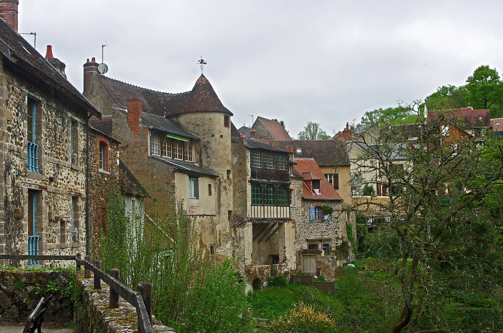 Photo showing: Gargilesse-Dampierre (Indre).
C'est à l'occasion d'une chasse aux papillons dans cette vallée, que George Sand découvre le village de Gargilesse un jour de juin 1857. George Sand a cinquante-trois ans, elle est célèbre, nous sommes en plein Second Empire. 
George Sand est accompagnée par Alexandre Manceau, son jeune amant, un ex-ami de son fils, et par Depuizet, un entomologiste renommé.
Alexandre Manceau, graveur de métier, achètera en juillet une petite maison de deux pièces collée à une autre maison. Il baptisera cette maison "Algira", du nom d'un papillon découvert dans la vallée. Georges Sand cherche une autre maison de le village, mais n'en trouve pas. Alexandre Manceau lui offrira la villa Algira. Comparée aux 12 pièces de Nohant, la maison de Gargilesse est inconfortable, mais le calme incomparable.
Le décès d'Alexandre Manceau, de tuberculose, le 21 août 1865, mettra un terme aux séjours de Georges Sand à Gargilesse.
Il reste des écrits :
"Gargilesse est un nid bâti au fond d’un entonnoir de collines rocheuses où se sont glissées des zones de terre végétale. Au-dessus de ces collines s’étend un second amphithéâtre plus élevé. Ainsi de toutes parts le vent se brise au-dessus de la vallée, et de faibles souffles ne pénètrent au fond de la gorge que pour lui donner la fraîcheur nécessaire à la vie. Vingt sources courant dans les plis du rocher ou surgissant dans les enclos herbus entretiennent la beauté de la végétation environnante. La population est de six à sept cents âmes. Les maisons se groupent autour de l’église, plantée sur le rocher central, et s’en vont en pente, par des ruelles étroites, jusque vers le lit d’un délicieux petit torrent dont, à peu de distance, les eaux se perdent encore plus bas dans la Creuse. 
[…]
Toutes les maisons de Gargilesse sont construites sur le même plan. Le rez-de-chaussée, avec une porte à cintre surbaissé, ou à linteau droit, formé d’une seule pierre gravée en arc à contrecourbe, n’est qu’un cellier dont l’entrée s’enfonce sous le balcon du premier étage, quelquefois entre deux escaliers de sept à huit marches assez larges, descendant de face. Au premier, une ou deux chambres; au-dessus, un grenier dont la mansarde en bois ne manque pas de caractère. Beaucoup de ces maisons paraissent dater du XIVe ou du XVe siècle. Elles ont des murs épais de trois ou quatre pieds et d’étroites fenêtres à embrasures profondes, avec un banc de pierre posé en biais. On a presque partout remplacé le manteau des antiques cheminées par des cadres de bois; mais les traces de leurs grandes ouvertures se voient encore dans la muraille. Les chambres de ces vieilles maisons rustiques sont mal éclairées, d’autant plus qu’elles sont très spacieuses. Le plafond, à solives nues, est parfois séparé en deux par une poutre transversale et s’inclinant en forme de toit, des deux côtés. Le pavé est en dalles brutes, inégales et raboteuses. L’ameublement se compose toujours de grands lits à dossier élevé, à couverture d’indienne piquée, et à rideaux de serge verte ou jaune sortant d’un lambrequin découpé, de hautes armoires très belles, de tables massives et de chaises de paille. Le coucou y fait entendre son bruit monotone, et les accessoires encombrent les solives: partout le filet de pêche et le fusil de chasse.
Il y a, dans ce village, des constructions plus modernes, des maisonnettes neuves et blanches, crépies à l’extérieur, et dont les entourages, comme ceux du château, sont en brique rouge. 
Grâce à leurs petits perrons et aux vignes feuillues qui s’y enlacent, elles ne sont pas trop disparates à côté des constructions primitives qui montrent leurs flancs de pierres sèches d’un brun roux, leurs toits de vieilles tuiles toutes pareilles de ton et de forme à cette pierre plate du pays, et leurs antiques encadrements de granit à pans coupés. La couleur générale est sombre mais harmonieuse, et les grands noyers environnants jettent encore leur ombre à côté de celle des ruines de la forteresse."

George Sand. Promenade autour d’un village.