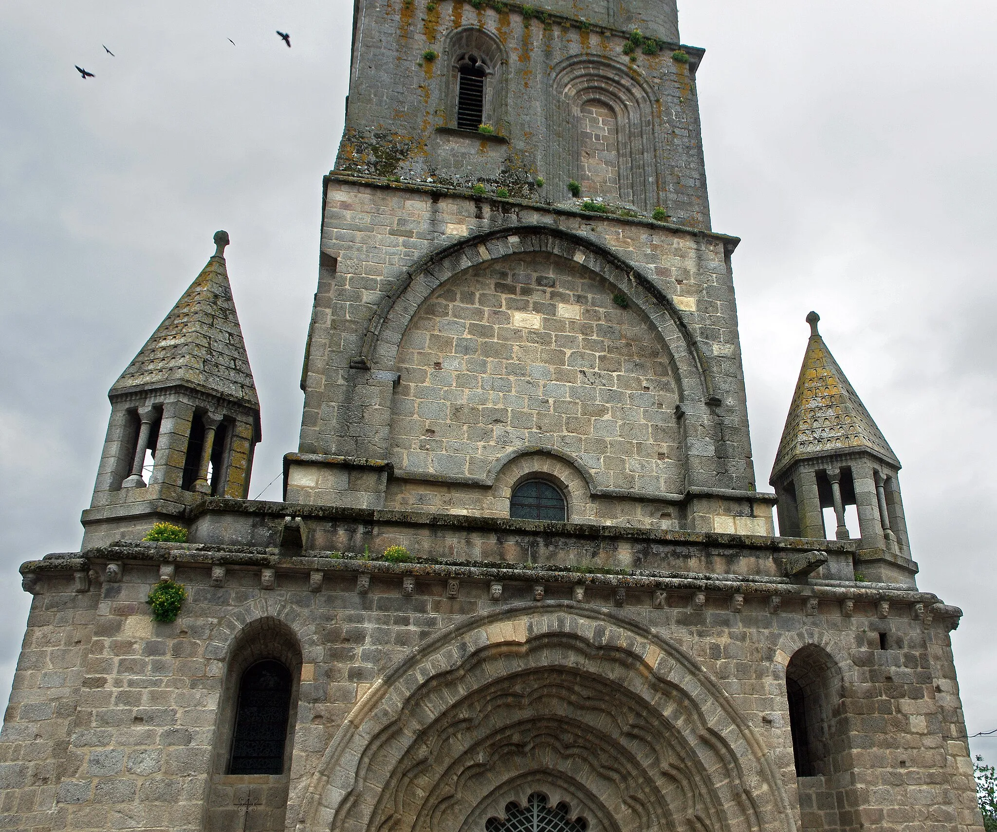 Photo showing: La Souterraine (Creuse).
Eglise Notre-Dame.
L'église Notre-Dame (De son vrai nom église paroissiale de l’Assomption-de-la-Très-Sainte-Vierge),se situe sur un des chemins menant à Saint Jacques de Compostelle. L'édifice a été restauré par l'architecte Abadie au milieu du XIXème siècle.
La collégiale romane, chef-d'œuvre de transition du roman vers le gothique. Restaurée par Abadie au XIXe siècle, elle conserve une crypte, construite par les moines de l'abbaye Saint-Martial de Limoges aux environs de 1020 pour servir de sépulture au fondateur Gérald de Crozant.
Juste après l'An Mil, Gérald de Crozant* fait don* d'une villa (Villa Sosteranea) à l'Abbaye Saint Martial de Limoges. Celle-ci y crée un Prieuré dont le premier prieur est Rodolphe Barton. Les moines de l'abbaye Saint Martial prennent possession d'un sanctuaire souterrain issu d'une nécropole gallo-romaine,  et la christianisent avec une relique de la vierge, ce qui attire de nombreux pèlerins.  La crypte agrandie et transformée* en une église souterraine comprend trois chapelles dont une héberge deux sarcophages d'époque gallo-romaine. Les moines utiliseront la crypte pour y placer la sépulture du donateur. Les moines entreprirent aussi la construction de l'église Notre Dame* qui dura deux siècles et est achevée au début du XIIIème siècle, vers 1230*.
La première partie, les deux premières travées de la nef, sont de style Roman. Le clocher, les trois dernières travées de la nef le transept et le choeur sont de style Gothique.
Le Portail principal est remarquable avec ses trois voussures polylobées d'inspiration mozarabe. Il témoigne du brassage de populations et du passage des pèlerins de Saint Jacques provoquant le mélange des styles avec des apports en provenance d'Espagne. Chaque voussure comporte une partie plane et un tore tous deux festonnés.
Le clocher est rectangulaire à trois étages, il est du XIIIème siècle, remanié au XVème et le beffroi du haut est postérieur. Il mélange les styles car sa construction d'origine a subi de nombreux rajouts, à l'instar de la lanterne et de la flèche recouverte de bardeaux.
Le premier étage présente une grande arcade sur chaque face, les baies du deuxième étage sont inégales et le troisième n'a que deux baies avec des tourelles d'angles. 
Le chevet est plat et soutenu par de puissants contreforts, de même que les bras du transept.
Une crypte ancienne est située sous le choeur, elle est voûtée en ogives. On y a retrouvé les traces d'un édifice Gallo-Romain.

Gérald de Crozant, vicomte de Bridiers. On croit Gérald de Crozant neveu de Bernard Ier comte de la Marche. D'après le chroniqueur Geoffroy de Vigeois (Geoffroy de Breuil devient prieur de Vigeois à partir de 1178), vers 1017, Géraud (francisé, selon les auteurs, en Gérald ou Gérard), comte de Crozant, vicomte de Bridiers, vassal du Duché d'Aquitaine, fit don de la "Villa Sosterranea" (village de La Souterraine) à l'Abbaye Saint-Martial de Limoges. Les premiers travaux ne concernant que la crypte démarrèrent en 1017 et durèrent 5 ans. Le nom "La Souterraine" en découle. La construction de l’église haute débuta vers le milieu du XIIe siècle et ne fut achevée que mi-XIIIe siècle. L’église mélange ainsi différents styles : roman (au niveau des deux premières travées de la nef) et gothique (transept, chœur, clocher et les trois dernières travées de la nef). Développée en prieuré et prévôté monastique de Saint-Martial au début du XIIIe siècle – ce dont témoigne un autre chroniqueur limousin, Bernard Itier – La Souterraine contrôlait une douzaine de paroisses dans le diocèse de Limoges.