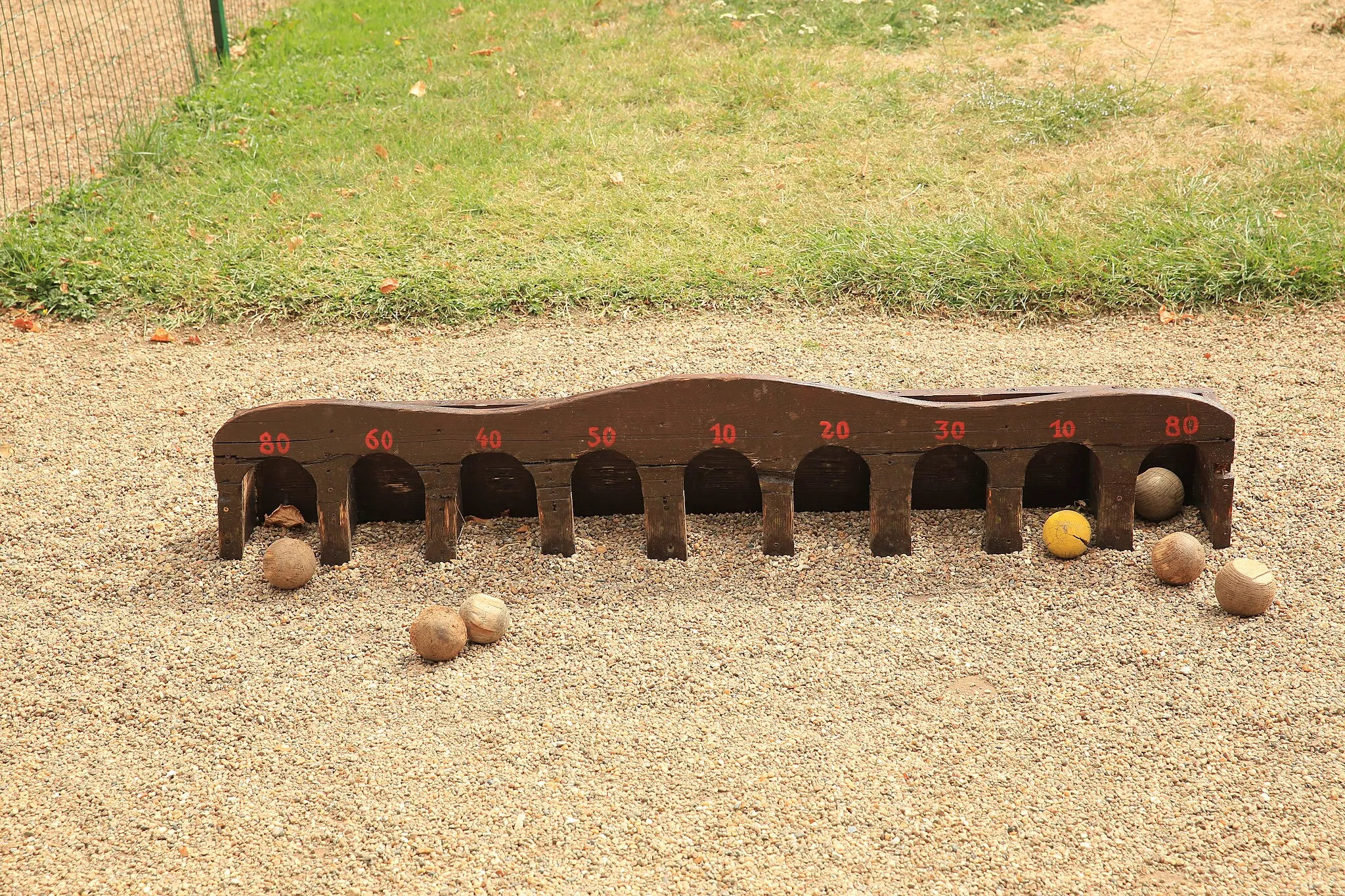 Photo showing: Trou madame. Jeu traditionnel en bois à l'entrée du Domaine de Chanteloup. Il faut lancer les boules plates d'une distance de trois à quatre mètres pour les faire entrer dans un des neuf trous.