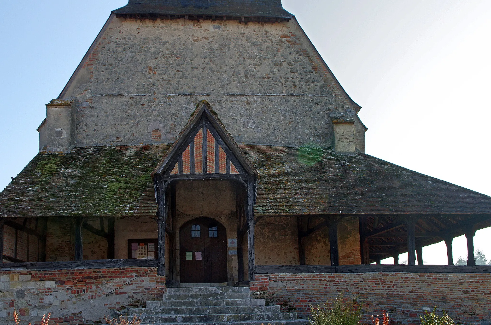 Photo showing: Brinon-sur-Sauldre (Cher).
Eglise Saint-Bathélémy (XIe - XIIe siècle).
Jusque vers 1800, l’église porte le vocable de Saint Aignan qui est ensuite remplacé par celui de Saint Barthélemy.
La particularité de l’église est son "caquetoire". C’est une galerie extérieure construite sous charpente et auvent, sur un soubassement en pierre et brique. Elle garnit non seulement la façade mais également une grande partie du côté sud. On peut en dater la construction au XVe-XVIème siècle, après l’affranchissement des habitants. Le caquetoire servait d’abri aux réunions paroissiales qui se tenaient à la sortie de la messe sous la présidence du bailly. Il servait aussi d'abri, de halles pour les marchés et de lieu de repos et de discussion entre les paroissiens qui venaient y "caqueter"…
C'est le dernier caquetoire du Département du Cher.

Une aquarelle de Paul Signac (1863-1935), représentant l'église de Brinon-sur-Sauldre, datée de 1929, était mise en vente à Versailles, en 2015. (www.pillon-encheres.com/html/fiche.jsp?id=5175053&np=...)