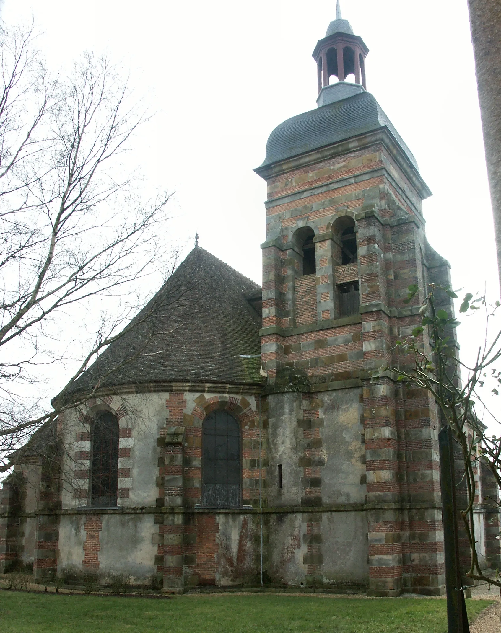 Photo showing: La tour-clocher quadrangulaire est accolée à l’abside au nord ouest. L’église est orientée nord ouest-sud est. CMH 1976. Vue du nord.