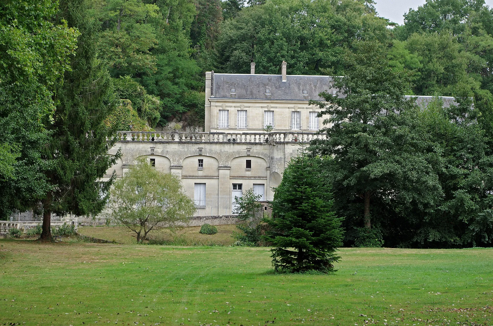 Photo showing: Saint-Paterne-Racan (Indre-et-Loire)
Château de la Roche-Racan.
Château de la Roche Racan (2e quart 17e siècle)
Le château construit à partir de 1634, domine la vallée de l'Escotais. La terrasse fut établie en 1880 et refaite en 1895. L'ensemble est ainsi décrite dans l'aveu de 1711 : "le dit chastel consistant en un grand pavillon avec tourelle au coin de celui-ci, un autre pavillon servant de chapelle, entre lequel pavillon, il y a un grand corps de logis et plusieurs autres bâtiments".
Le fief, connu depuis le début du XVe siècle, sous le nom de la Roche majeur*, relevait de la prévôté d'Oë. Le fief qui en 1405 appartenait à Hardouin des Fontaines* passa par alliance à la famille de Bueil.
Le château actuel fut construit à partir de 1634 par Honorat de Bueil*, baron de Racan.
Parmi les ouvriers auxquels Honorat de Bueil, commanda la construction on remarque Jacques Gabriel*, maître maçon, puis maître architecte en 1652.
Il ne reste plus du corps de logis prolongé de deux pavillons que l'aile ouest et une partie du bâtiment central.
Le 2 novembre 1745, Antoine Pierre de Bueil vend La Roche Racan à Michel Rolland des Escotais, seigneur de Chantilly, en Anjou. Michel des Ecotais (Escotais) chercha en vain à faire nommer le domaine "La Roche des Ecotais"; en revanche, le ruisseau qui arrose le vallon prit alors le nom de "l'Ecotais" qu'il a gardé. La famille des Ecotais émigra en 1791; ses bien furent saisis et vendus.
A la Révolution, le château est acquis, en adjudication, par Etienne René Méhabert.
La veuve de René céda le château le 7 mars 1818 au sieur Michel Mathurin Mabille, qui démolit le pavillon en contre-haut de la chapelle et qui établit dans les cuisines et les écuries une fabrique de poterie.
Au sieur Mabille succéda le 27 février 1828 le sieur Philarète Bardon de l'Héraudière. Après celui-ci vint le comte Jacques Antoine de Chalot, avec son épouse veuve de Talma*.
Le 10 novembre 1830, le château, en fort mauvais état, fut acquis par Aimé Bodin, professeur de rhétorique au lycée de Tours* et membre du conseil d'arrondissement de Tours. Paralysé par le choléra en 1832, il se retira au château en se livrant à ses études littéraires, en continuant l'exploitation de la fabrique de poterie.
En octobre 1845, M. Bodin vendit le château entièrement délabré à M. Alphonse Huet, avocat à Paris, qui le restaura. Il établit dans la vallée un bélier hydraulique qui envoie l'eau  quarante mètres plus haut, dans le parc, qu'elle arrose en cascades et en ruisseaux. En 1874, M. Huet fut obligé de revenir à Paris, où il mourut deux ans plus tard.
Le 17 juin 1875, M. Huet avait vendu le château à M. Francis Arthur Larreguy de Civrieux, officier de la Légion d'Honneur, ancien Président de section au Conseil de Préfecture de la Seine*. Il fit restaurer l'intérieur du château, il fit également détruire le vieux moulin à eau et assainir le ruisseau. Il du se rapprocher de Paris pour des raisons de famille et revendit le château en 1888 à M. Pierre Gauthier, négociant et propriétaire d'un magasin de confection à Paris.
Pierre Gauthier fera une somptueuse restauration de la terrasse, en coupant beaucoup d'arbres, il développera les vignes sur le côteau, vignes qui donneront un vin "Clos de la Roche-Racan".
Après la succession de 3 propriétaires au 20e siècle, le château de la Roche est racheté en 1963 par M. Marcel Brakers de Hugo, gérant de sociétés, et c'est depuis son décès, sa fille qui en est la propriétaire.

Cet ancien fief était connu sous le nom de la Roche au Majeur, indiquant ainsi que le seigneur était le "majeur" de son suzerain. Le seigneur majeur a pour rôle d'assurer l'intégralité du service du fief au suzerain. Le seigneur majeur ne possède pas forcément la coseigneurie la plus importante. On peut un peu voir le seigneur majeur comme un syndic de copropriété. Hardouin de Fontaine, sire de Fontaine-Guérin, est chevalier dans la compagnie de Pierre de Bueil  dont il épousera la fille alors âgée de moins de onze ans, en 1389. Le couple aura deux fils, dont Jean qui sera l'ancêtre du poète Racan. Honorat de Bueil (1589-1670), seigneur de Racan, nom qu'il associe à la Roche, est aussi poète, sous le nom de "Racan". Orphelin à 13 ans, il fut recueilli par des parents qui le placèrent comme page à la cour d'Henri IV. Il s'intéressa d'abord à la poésie, mais aussi à la musique et les mathématiques. En 1605, il fut présenté à Malherbe qui allait pour lui un maître et un ami. Il laissera une grande œuvre, les "Bergeries" (1619), une pastorale dramatique de près de 3?000 vers. Oeuvre jamais jouée en entier, mais qui fut un succès de librairie avec une douzaine de rééditions en 10 ans.  Les plus beaux passages, comme les «Plaintes du vieil Alcidor», furent récités à l'hôtel de Rambouillet et dans tous les salons. Ses obligations militaires, il prit part aux guerres contre les protestants, l'éloignèrent de la cour et il finit par se retirer dans son château, mais en continuant d'entretenir une correspondance ses amis parisiens, Chapelain, Conrart et Ménage.  Il sera un des premiers académiciens, nommés à la fondation de l'Académie Française par Richelieu (1634), il y fera le douzième discours.  Il laissera des Mémoires pour la Vie de Malherbe (1651). Jacques II Gabriel est un maître maçon, issu d'une dynastie d'architectes normands. Il a été baptisé à Argentan le 16 octobre 1605. Il s'est ensuite établi à Saint-Paterne vers 1636, où il serait mort en 1662. L'un de ses enfants, Jacques V Gabriel (1667-1742), aura une production architecturale importante: Construction de l'hôtel de ville de Blois et du pont Jacques-Gabriel, des hôtels particuliers place Vendôme à Paris, construction des bâtiments de la Compagnie des Indes à Lorient, etc... En 1826, la comédienne Charlotte (dite Caroline) Vanhove, veuve du tragédien le plus célèbre de son temps, Talma, épouse le comte de Chalot, un cavalier ami de longue date, qui meure rapidement. Elle meurt à 90 ans, en 1860, dans son hôtel parisien. Aimé Bodin, professeur de rhétorique à Tours, commettra quelques ouvrages "Conciones Religieux et Monarchiques, ou Matières de discours français et latins pour la rhétorique, tirée de l'histoire sacrée et de l'histoire de France", ou encore "Distiques Moraux, et Sentences d'Ovide" avec la traduction en vers français... Un critique, du Mémorial Catholique, probablement un confrère, fera remarquer : "Les sujets de discours français et latins que M. Bodin publie pour la classe de rhétorique ne sont pas toujours présentés avec toute l'exactitude et la précision qu'on pourroit désirer...". Alphonse Huet, avocat, en 1850 proposera quelques modifications à la loi électorale, pour y apporter de la "stabilité" : - Les électeurs de 21 à 25 ans auront chacun une voix.
- Les électeurs de 26 à 35 ans, chacun deux voix.
- Ceux de 36 ans et au-dessus, chacun trois voix.

Et cet honorable juriste fait remarquer : "N'est-il pas contraire à la morale, à la raison, à la justice, qu'un jeune homme de 21 ans ait, dans l'ordre politique, la même autorité, le même pouvoir que son père ?"
Et il en prend pour preuve que ce même jeune homme ne pourra pas se marier avant 25 ans, sans le consentement de son père. 
Et il insiste : "la société ne doit pas donner l'autorité aux plus jeunes, aux plus inexpérimentés, à peine de voir bientôt sombrer le vaisseau de l'État".
Au passage, il relève le principal défaut du suffrage universel: Sa mobilité. Et pour preuve, il souligne que les élections de 1848, "toutes démocratiques et socialistes"; et celles de 1849, "presque toutes dans le sens opposé".

Les Conseils de Préfecture étaient des organes de justice administrative. Les contentieux fiscaux représentaient une part très importante de leurs activités, et en particuler sur la patente et la contribution mobilière. Les Conseils de Préfecture furent supprimés en septembre 1926.
Voir : "Louis Arnould - Racan (1589-1670) Histoire anecdotique et critique de sa vie et ses oeuvres - Slatkine Reprints - Genève 1970"