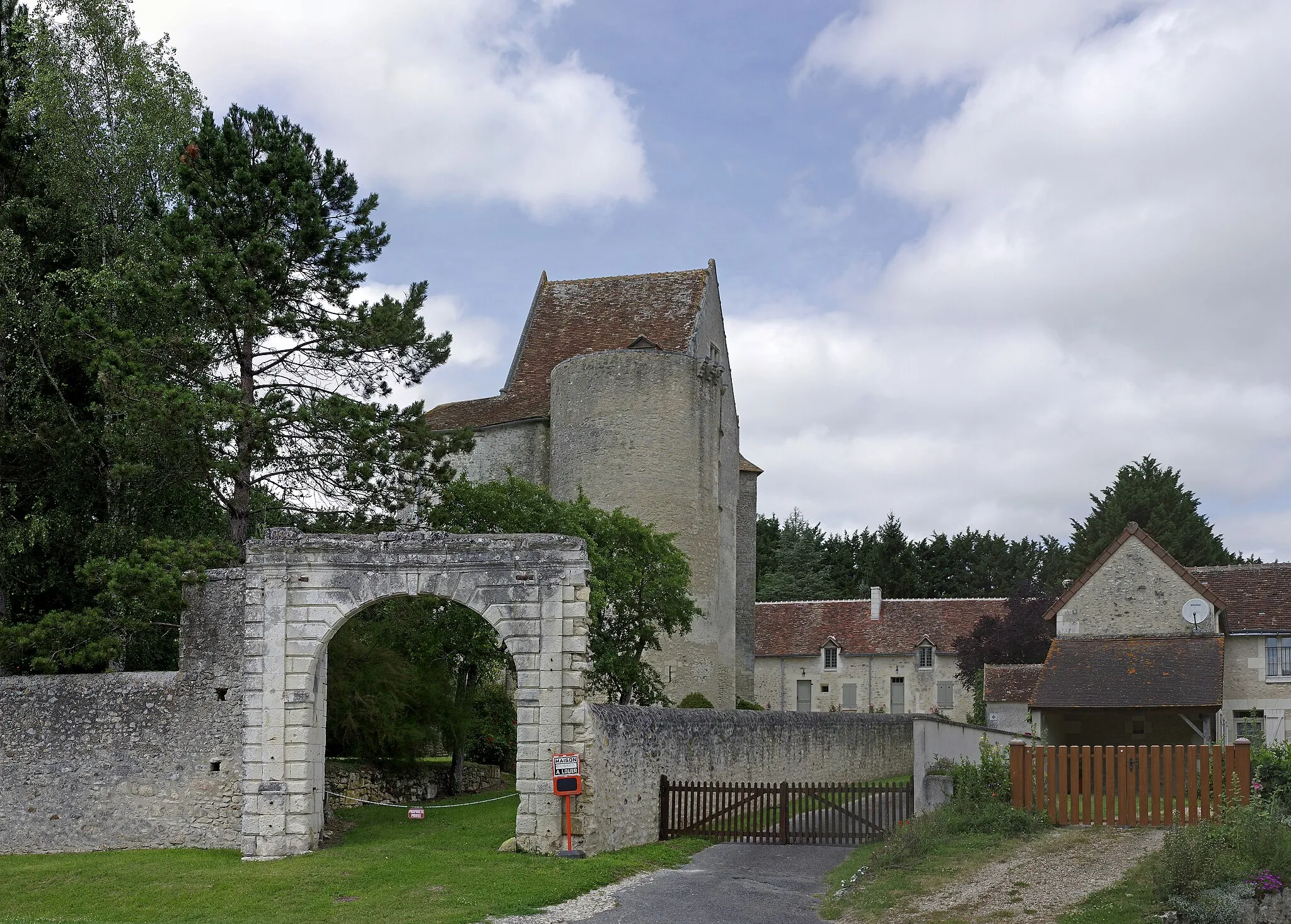 Photo showing: Betz-le-Château (Indre-et-Loire)
Château (XIVe siècle - XVe siècle)
Le château se trouve en contrebas du village, la motte castrale qui se trouve derrière le chevet de l'église n'ayant pas été réutilisée, ce qui est plutôt exceptionnel. Il subsiste un corps de logis de quatre étages du XVe, une tour circulaire dans  laquelle se trouve la chapelle, une tour-donjon carrée, et une tour polygonale avec un escalier. Le portail a été ajouté au 17e siècle. La construction de la D93 entraînera la destruction d'une partie des communs, et le comblement des douves.
La motte castrale aurait pu être édifiée par Gilles de Betz, premier seigneur connu du village, contemporain du comte d'Anjou Foulques III Nerra et du comte de Blois Eudes II.
Les seigneurs de Betz délaissèrent la motte castrale assez rapidement, et se sont fait construire un château en pierre peut-être dès le XIIe siècle (les fouilles de la motte castrale ne donnent pas de céramiques postérieures au XIe siècle).
C'est peut-être Pierre de Betz et Catherine de la Jaille, seigneurs de Betz de 1463 à 1501 qui donnèrent au château son aspect actuel.
La famille Betz conserva la seigneurie jusqu'au début du XVIe siècle, puis la famille Lusignan jusqu'au XVIIIe siècle. Les Chaspoux prirent la suite et intégrèrent le domaine dans le marquisat de Verneuil.
Le domaine était passé de la famille Betz à celle des Lusignan par le mariage de Renée de Betz, fille unique de Jacques de Betz et de Madelaine de Brilhac, avec  François de Couhé de Lusignan, en 1612.
La famille Chaspoux, issue de la bourgeoisie, cherchera à faire oublier son origine en se hissant au niveau de la noblesse. En 1746, les terres de Verneuil et autres lieux sont érigées en marquisat, au profit de Eusèbe Jacques Chaspoux, pour services rendus au roi comme conseiller, secrétaire, et introducteur des ambassadeurs et princes étrangers. En 1733, Hyacinthe Rigaud fera le portrait d'Eusèbe Jacques Chaspoux marquis de Verneuil, celui-ci a alors 42 ans. Le portrait est peint avec les mains cachées sous une draperie; avec les mains représentées, le portrait aurait coûté notablement plus cher.
www.mairiedebetzlechateau.fr/le-chateau-et-ses-souterrain...
tourainissime.blogspot.com/2009/06/betz-le-chateau.html
www.hyacinthe-rigaud.com/catalogue-raisonne-hyacinthe-rig...

(Samuel Riou et Flore Marteaux, « Une motte castrale dans le contexte des recompositions politiques au tournant de l’an mil (Région Centre, Indre-et-Loire) », Revue archéologique du Centre de la France, Tome 51)