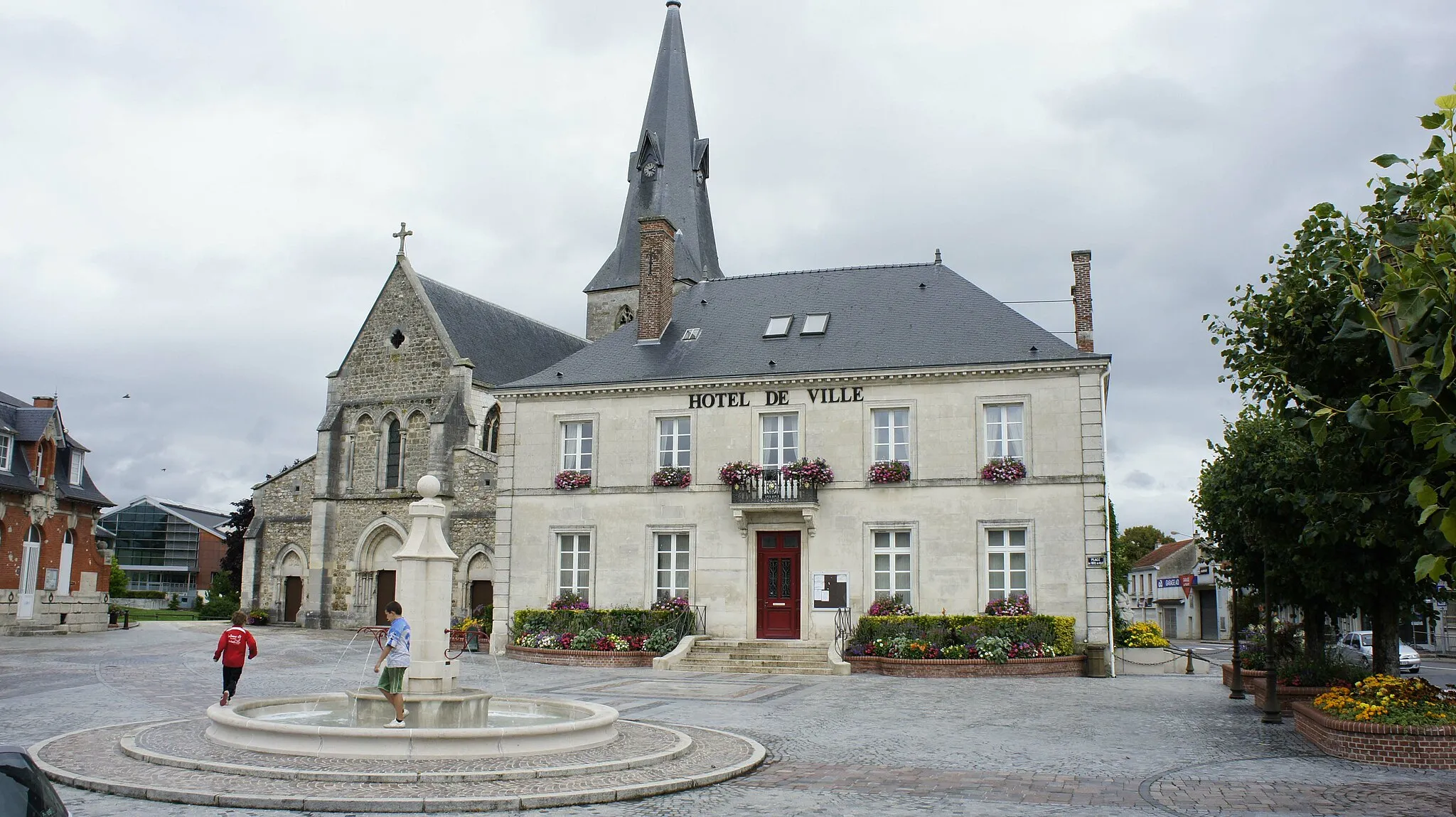 Photo showing: De gauche à droite : vue d'une partie du corps de garde, de la maison des associations (en retrait), de l'Église et de la mairie de Suippes.