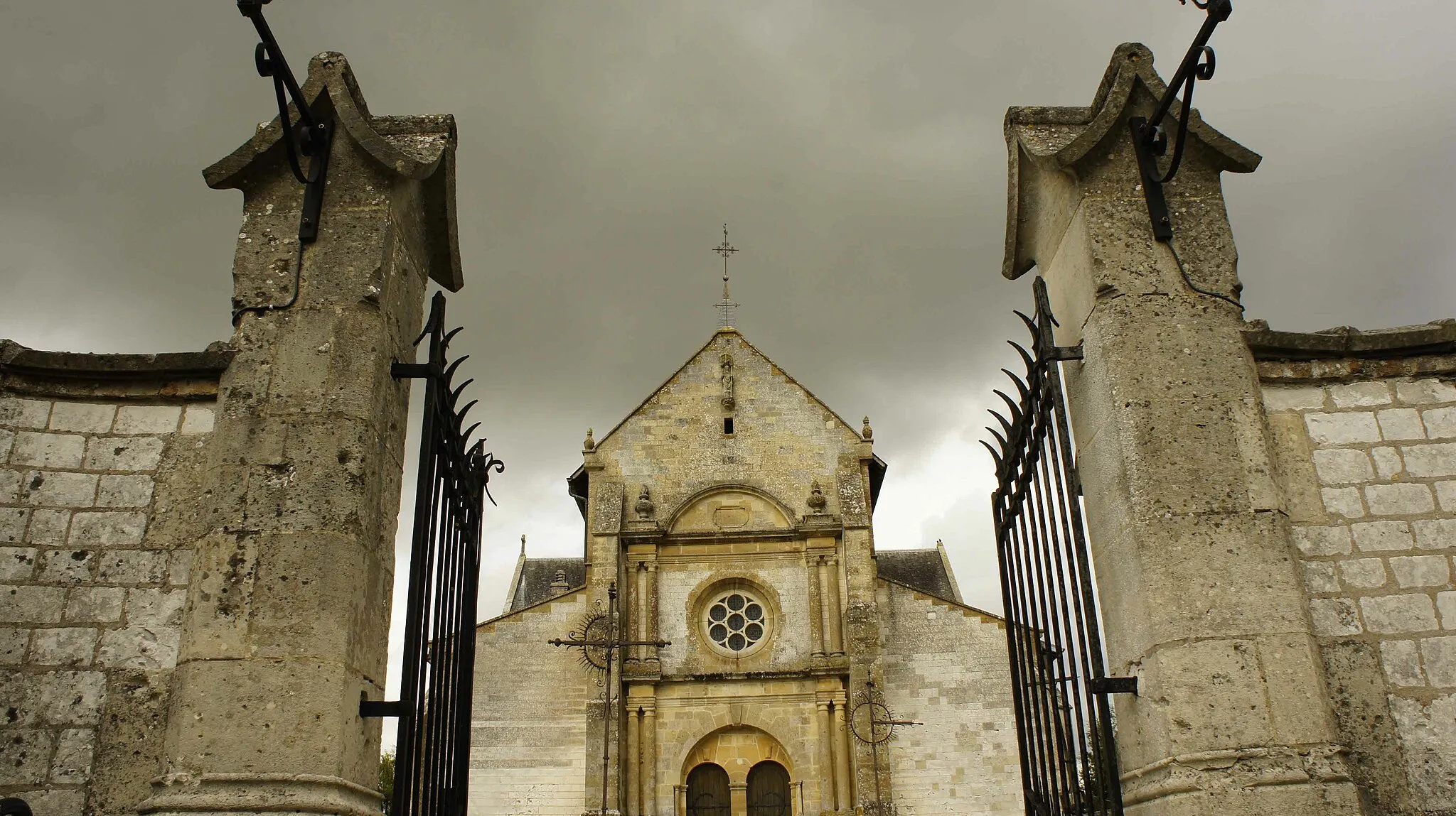 Photo showing: Vue en contre plongé du portail ouest de l'Église Saint-Martin de Sommepy-Tahure et du mur qui l'entoure avec le cimetière.