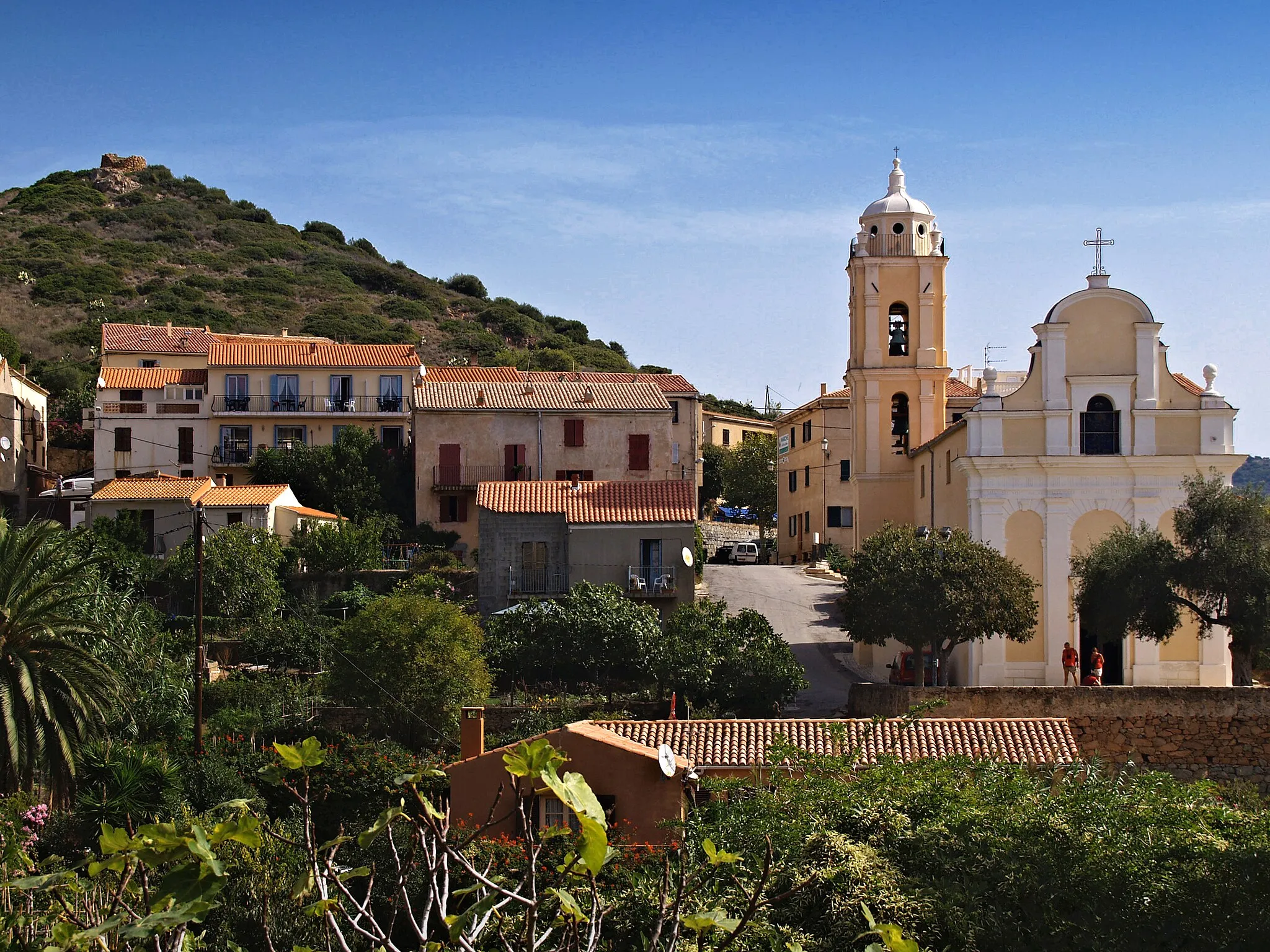 Photo showing: Cargèse (Corse) - Le quartier au sud-ouest du village avec l'église Latine. Au sommet de la colline, un moulin ruiné